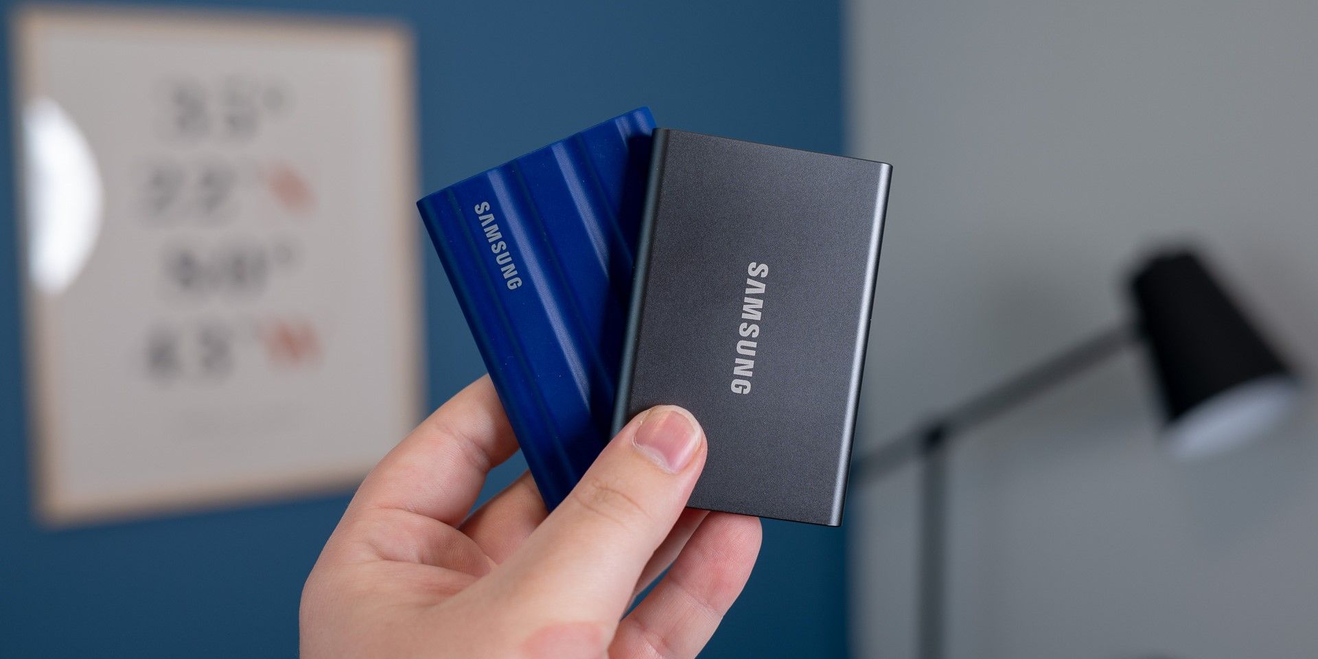 A person holding two Samsung portable SSDs