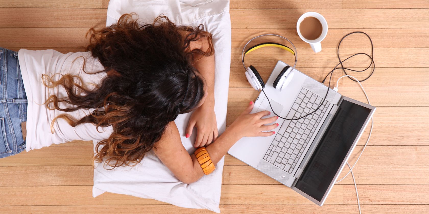 woman lying on floor using laptop while it charges