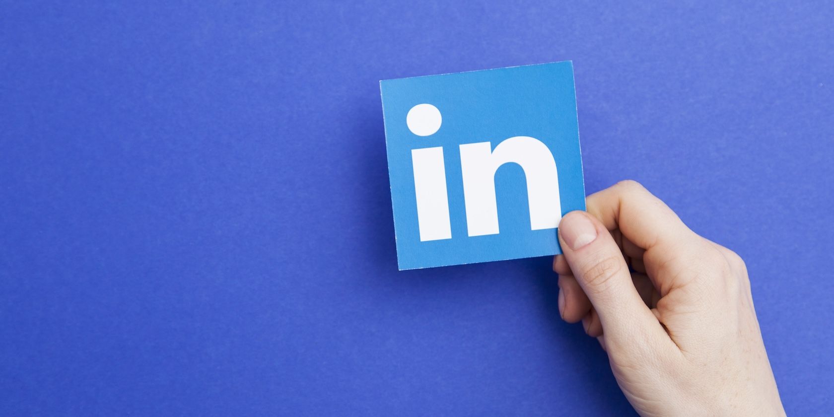 The LinkedIn logo—the word “in”—held in a hand