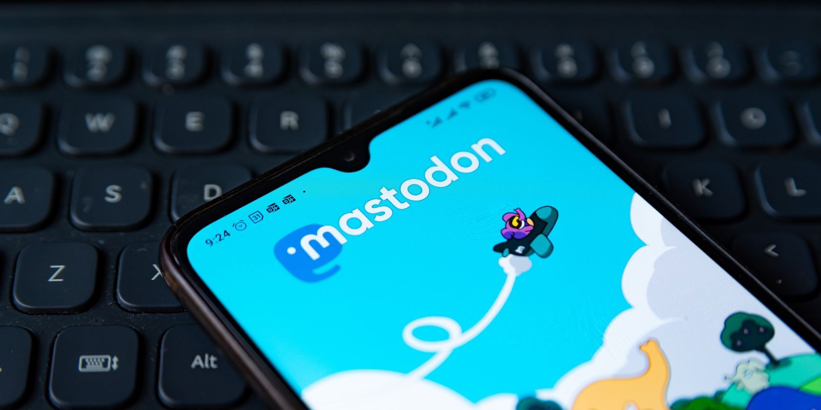 mastodon on a smartphone, with a keyboard in the background