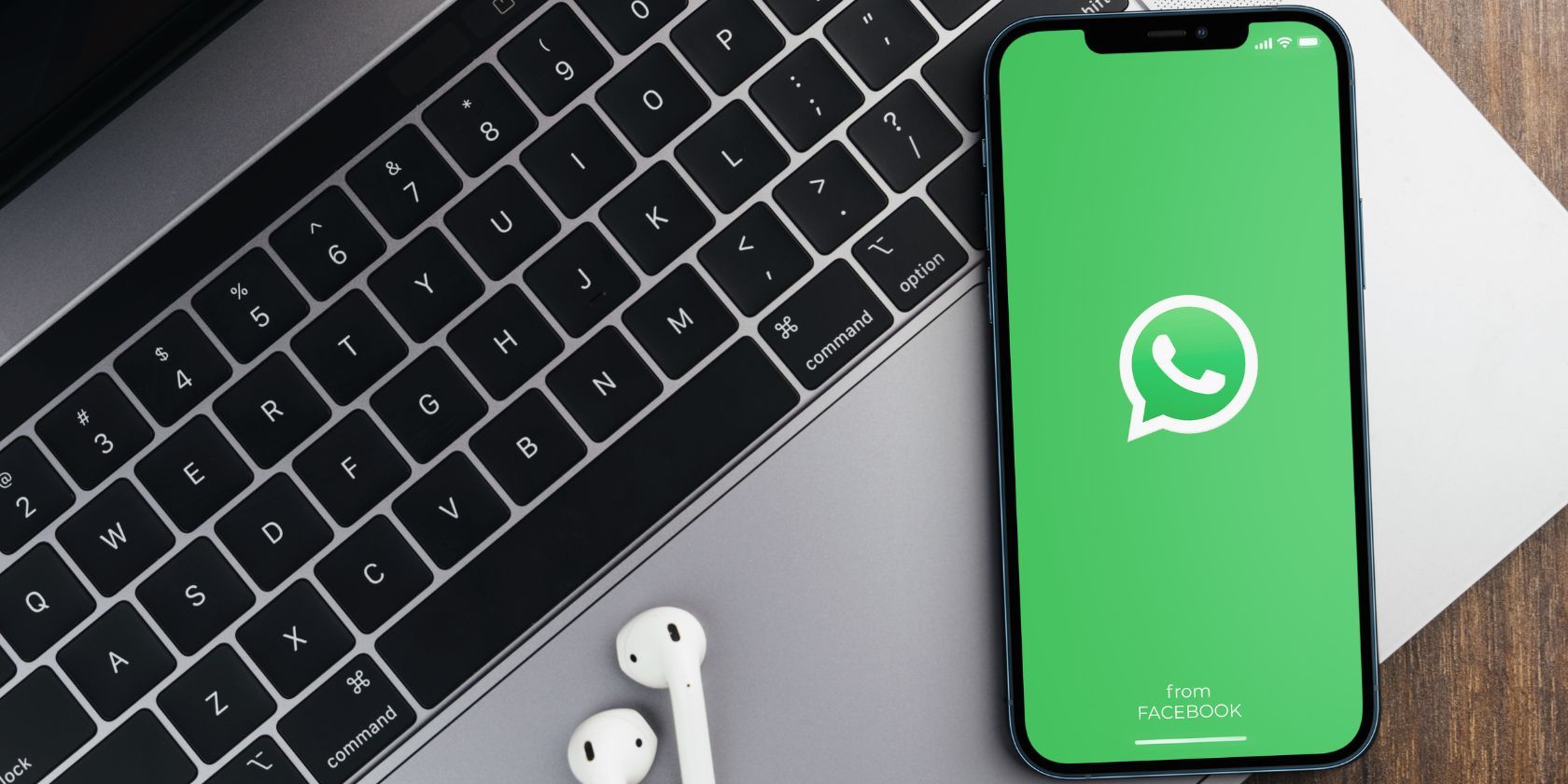 the whatsapp app on a smartphone with a laptop keyboard in the background
