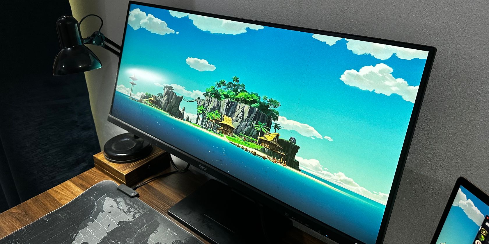 Ultrawide 4K monitor on a desk with a lamp