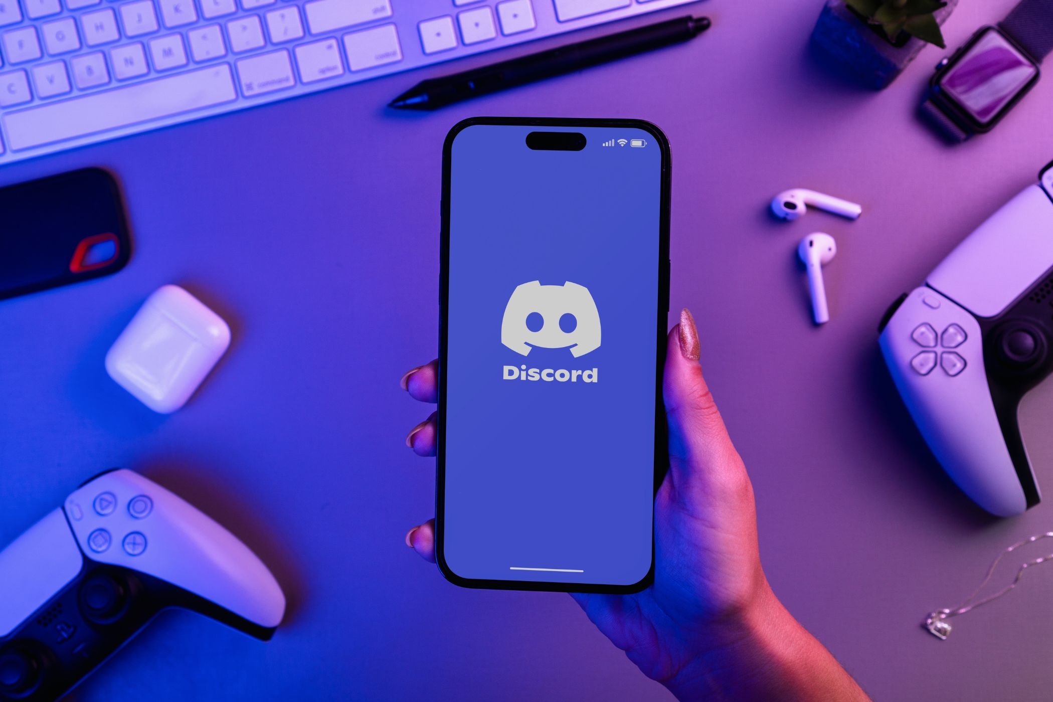 a person holding a smartphone with the discord logo