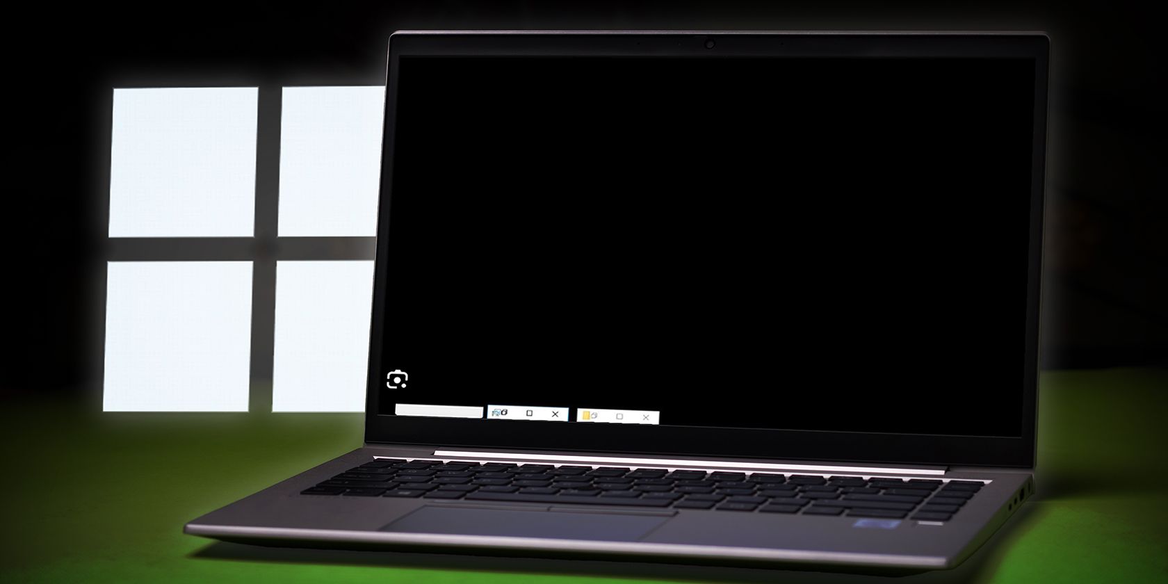 A laptop showing a blackscreen with the Windows logo on the side