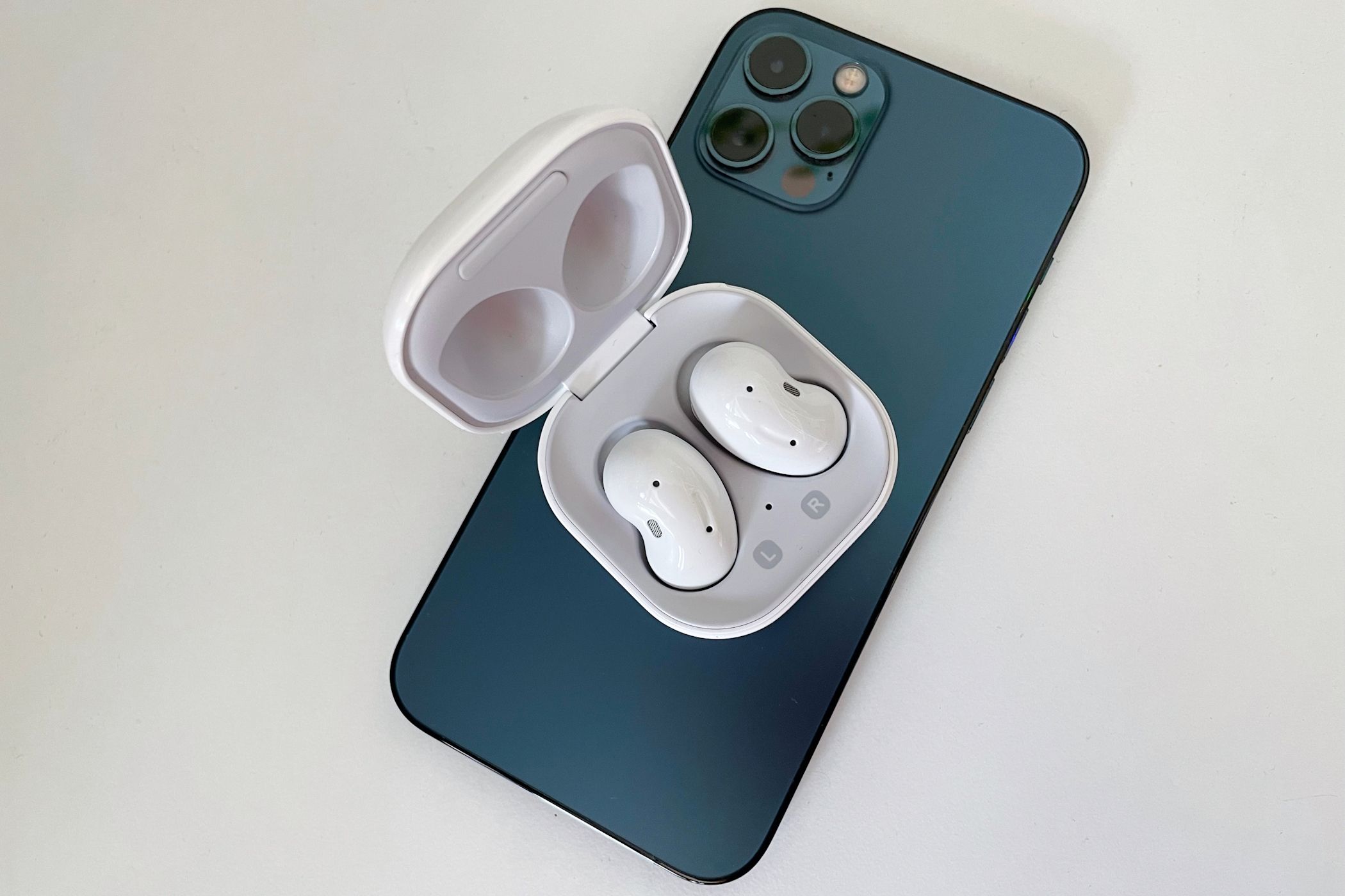 Galaxy Buds in a charging case on top of an iPhone