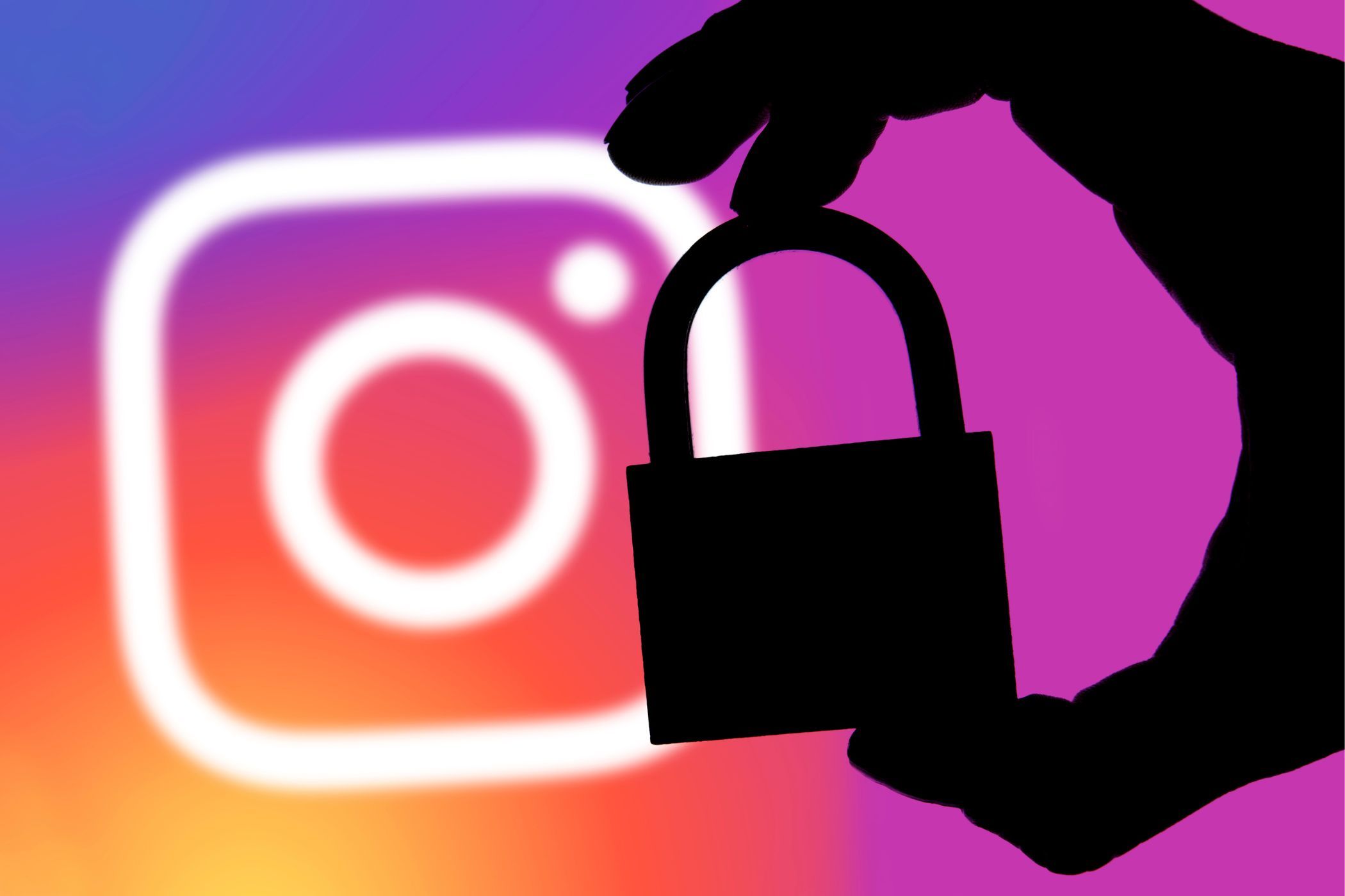 instagram logo in the background with silhouette of hand and lock