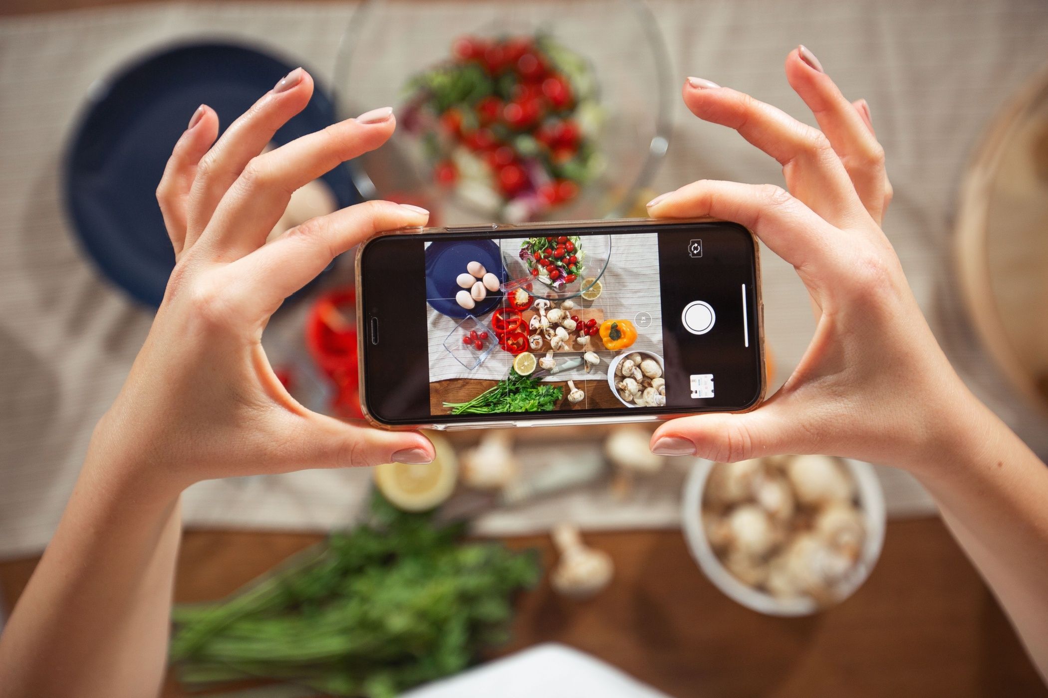 Two Hands Holding Smartphone Horizontally Taking Picture of Fresh Food on Cutting Board