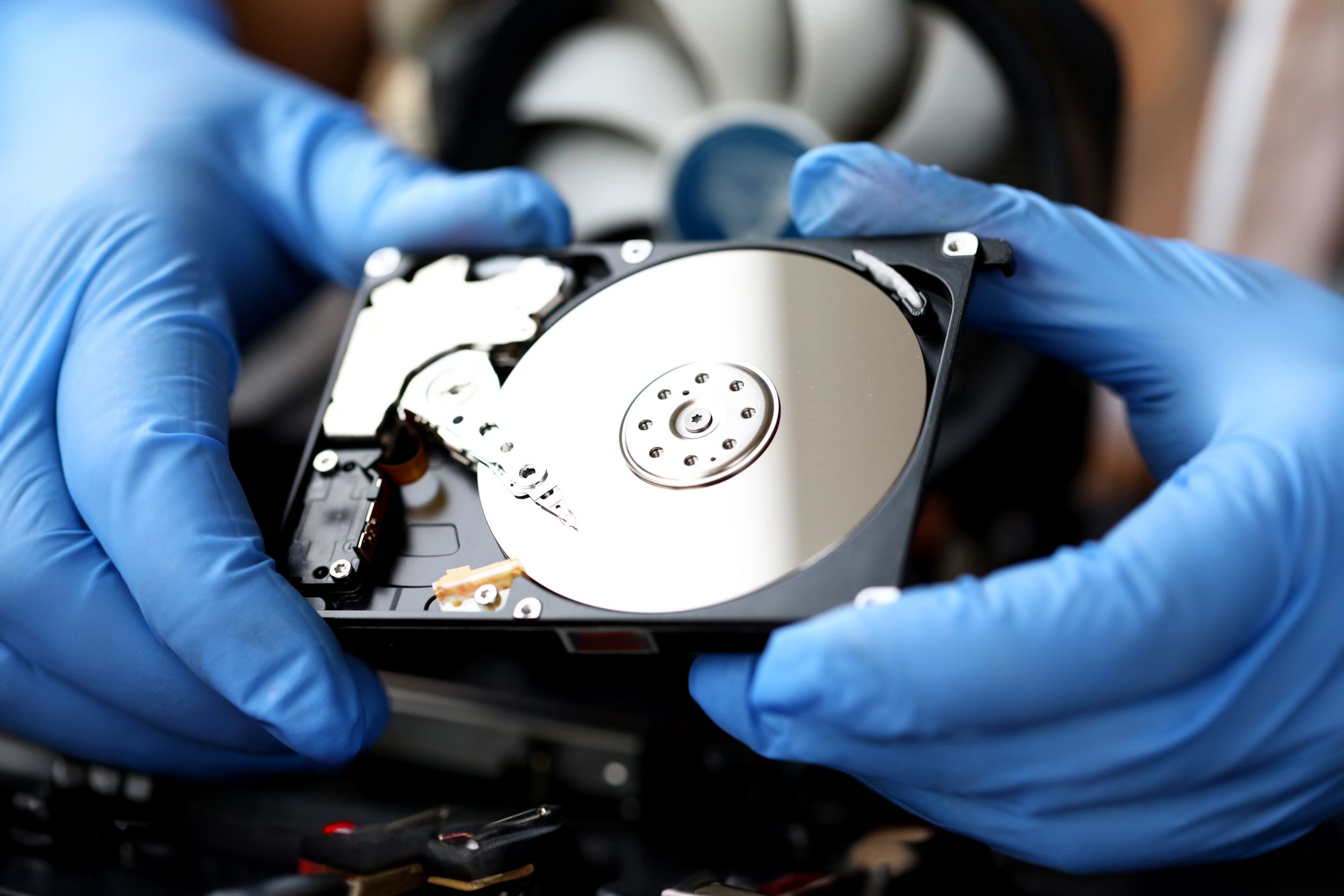 Person holding hard drive with disk platter showing.