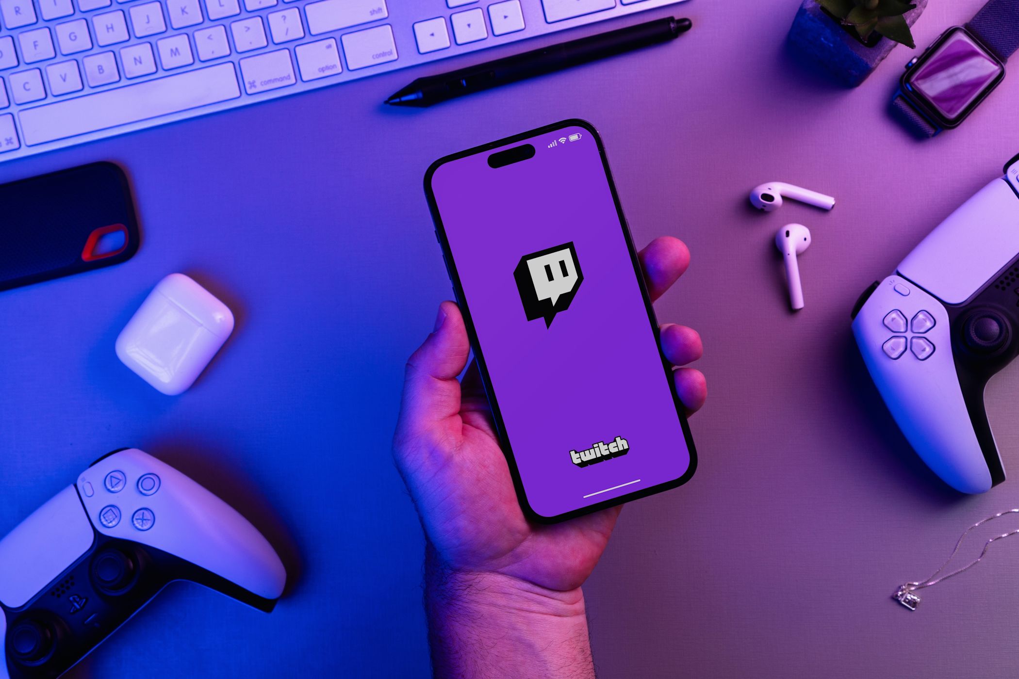 person holding smartphone with twitch logo