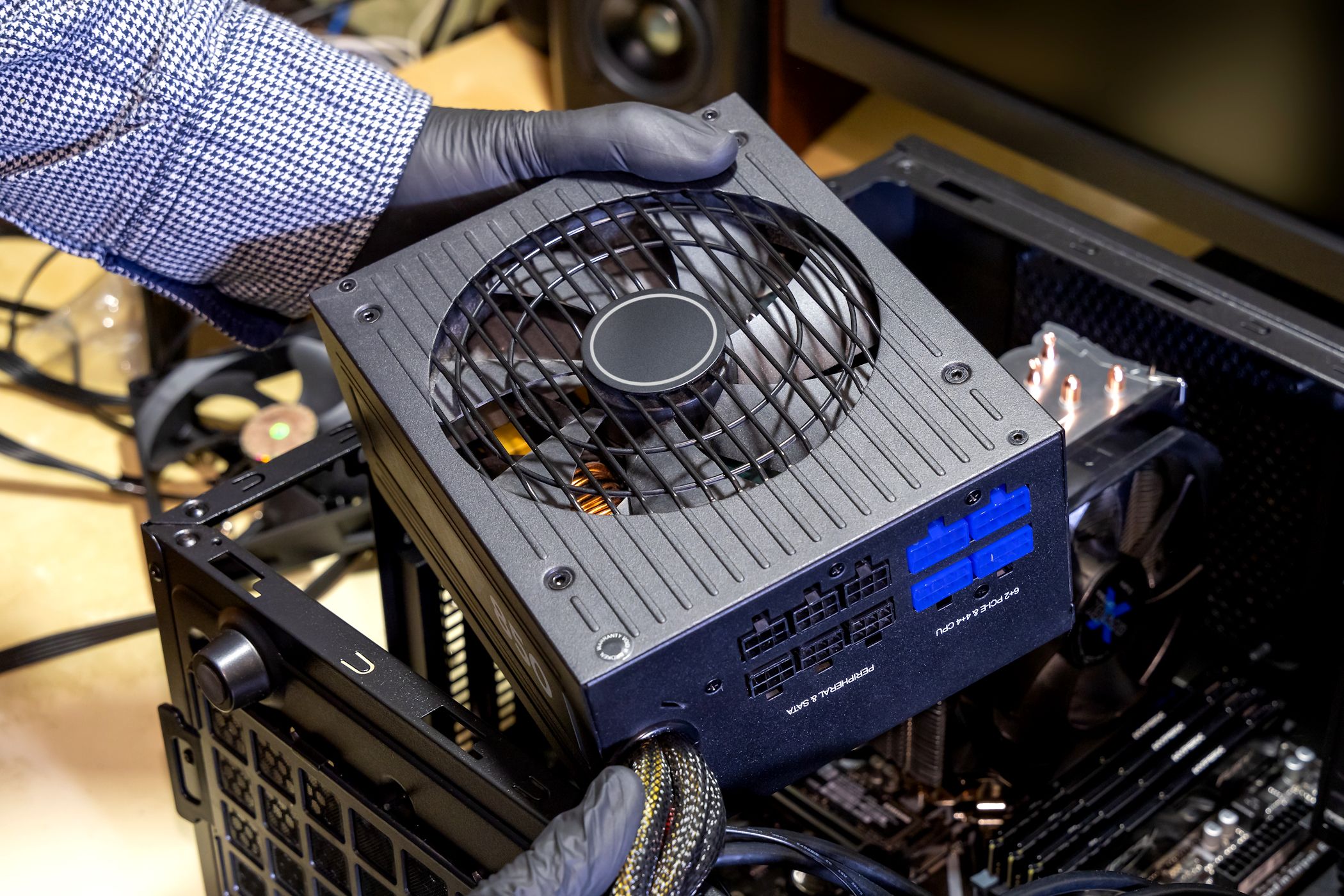 person putting power supply unit into pc case