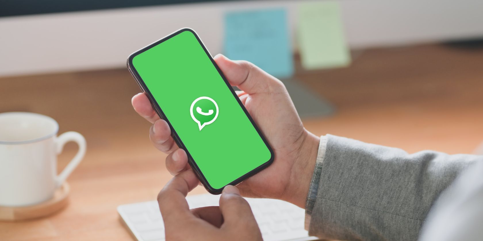 someone holding a phone in their hand with the whatsapp logo