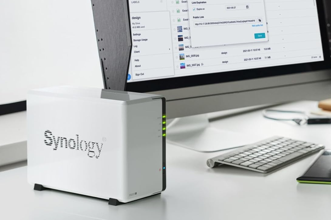 synology ds223j nas on desk, next to keyboard and monitor