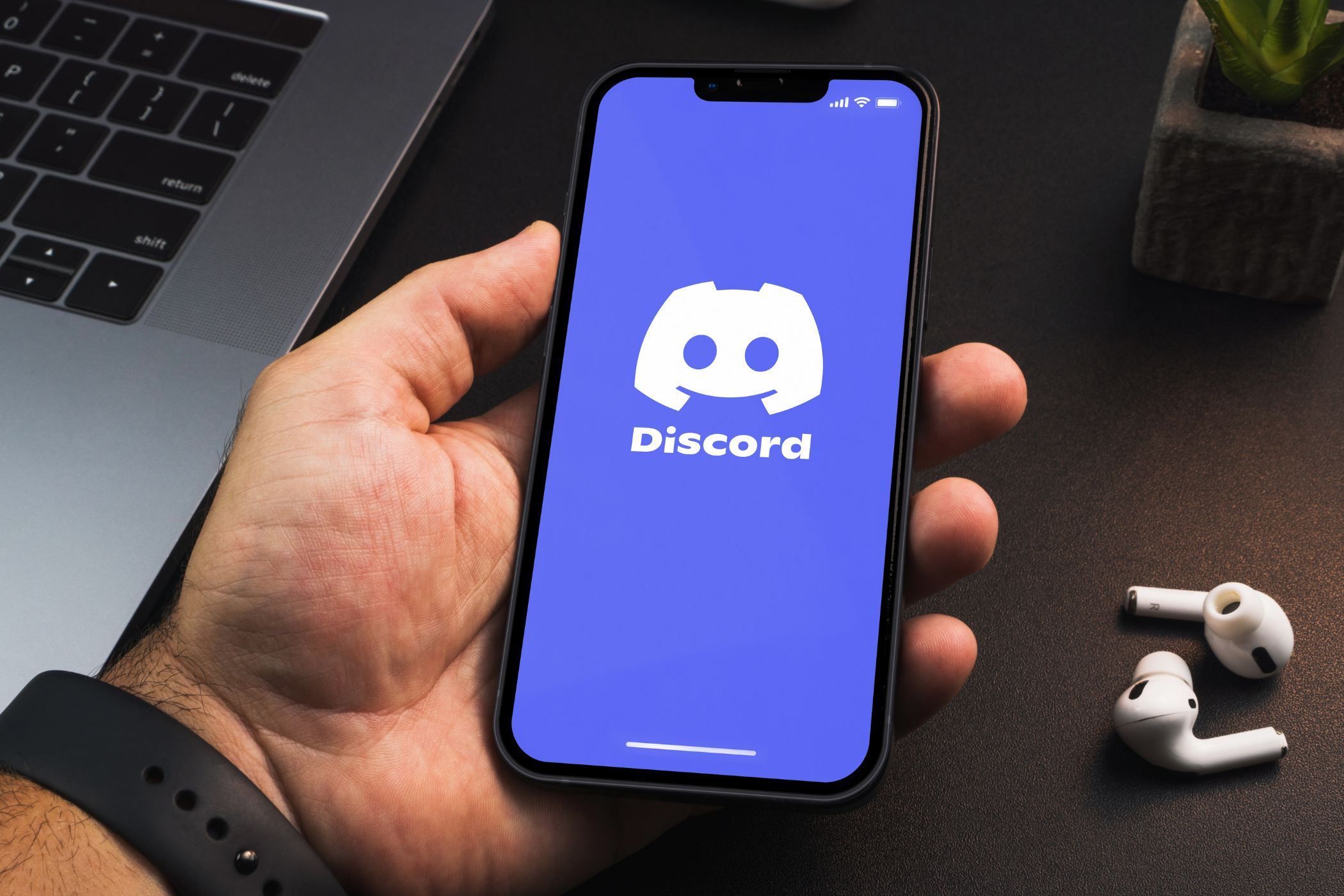 a man holding a smartphone with the discord app