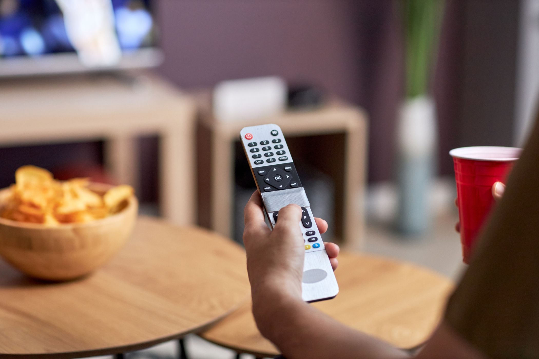 a person holding a tv remote