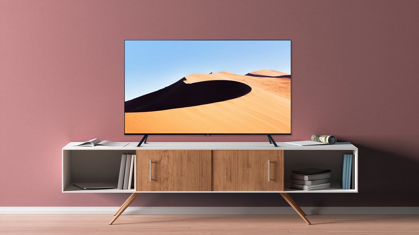 Samsung TV on a stylish stand in a sparsely decorated living space. 