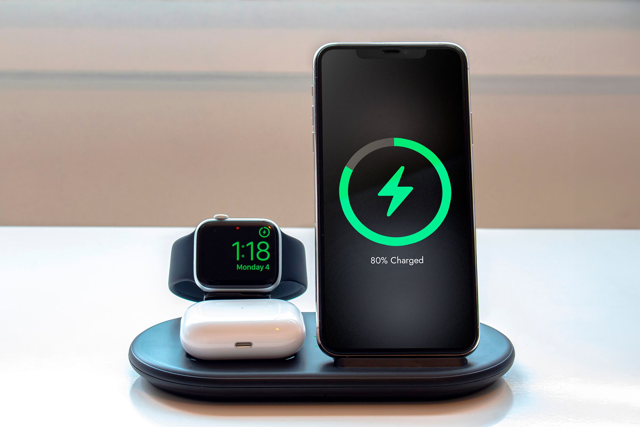 A charging station with an Apple Watch, an AirPod, and an iPhone with the battery at 80%.