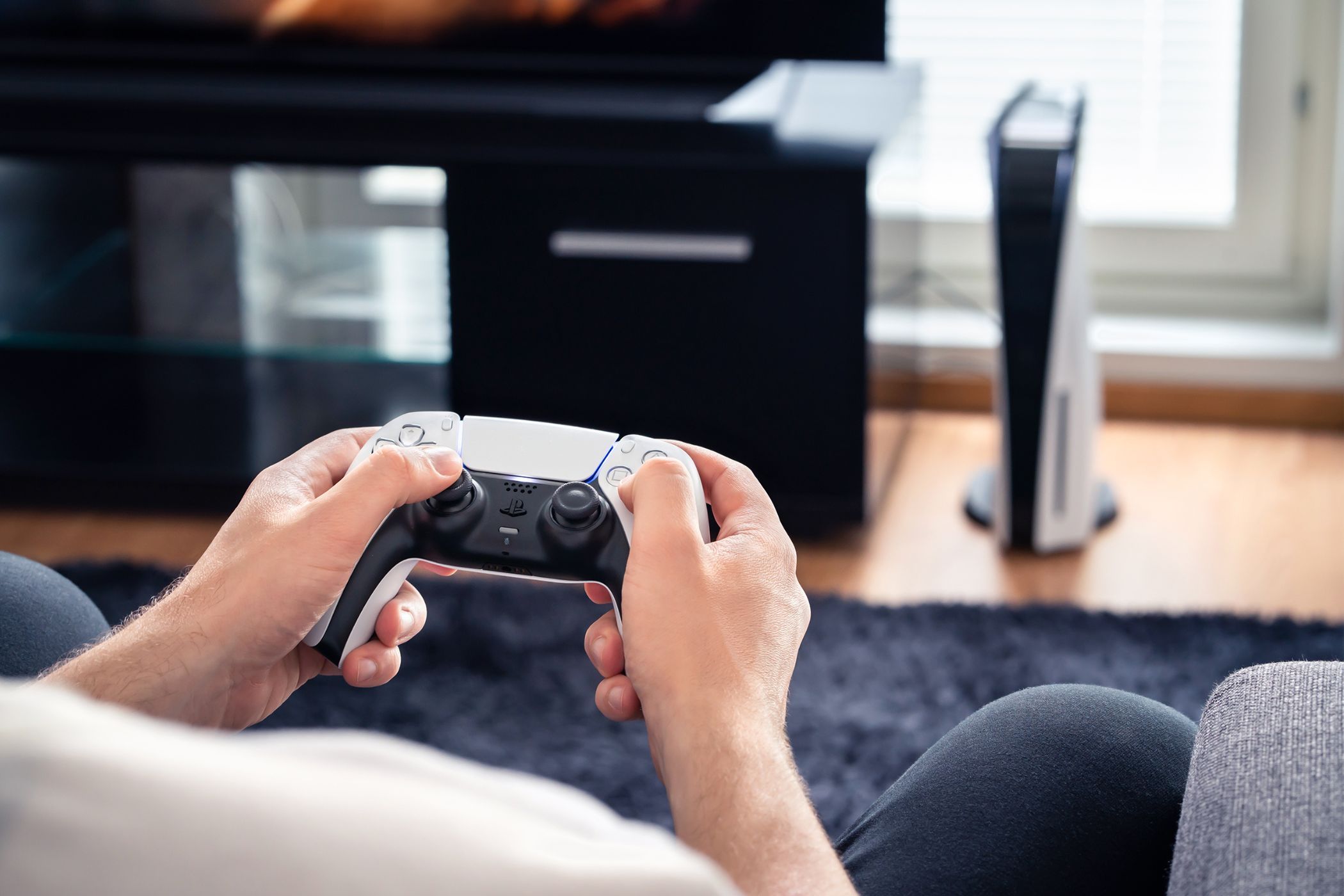 a person using the ps5 console while sitting on a couch