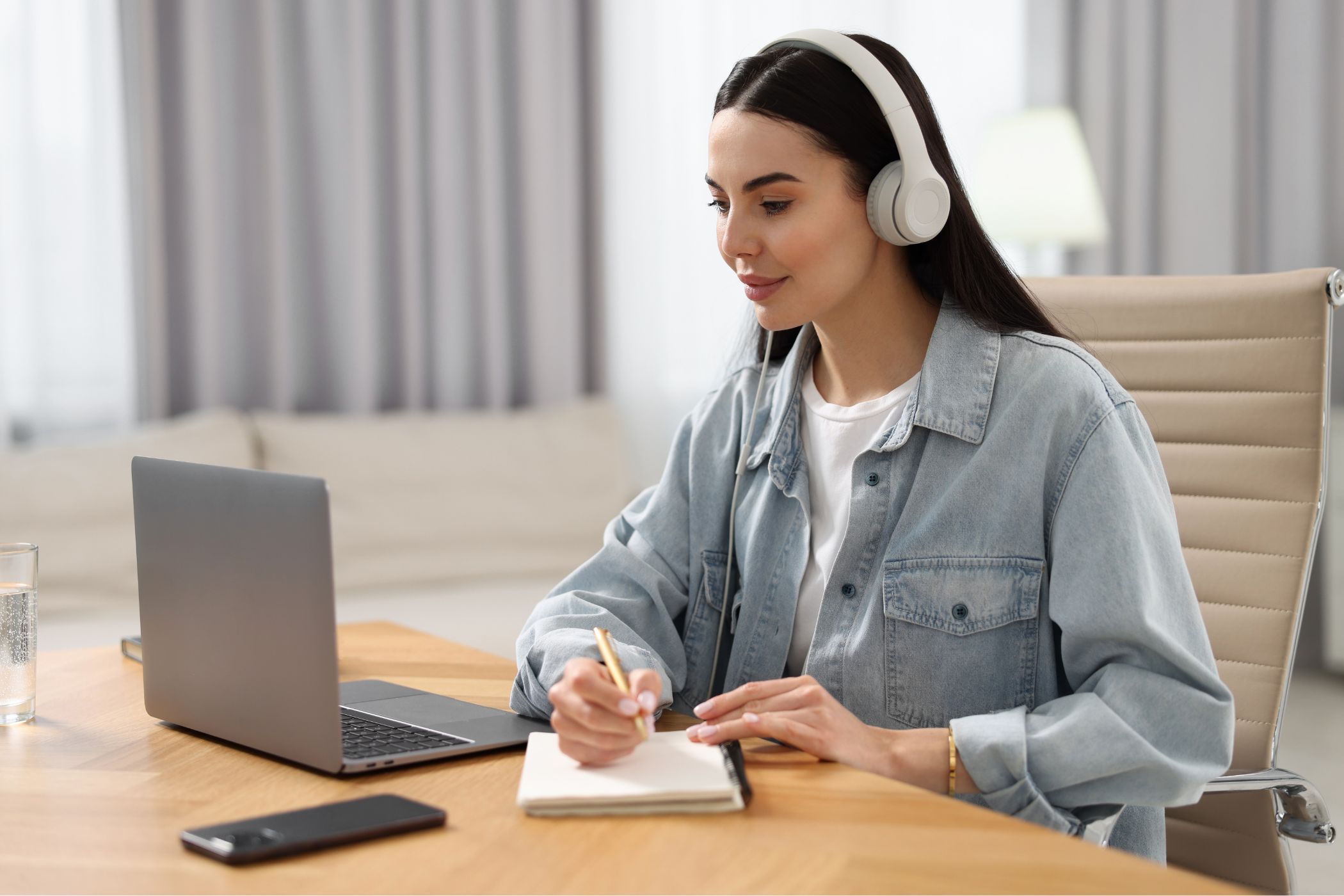 a woman using a laptop with headphones on