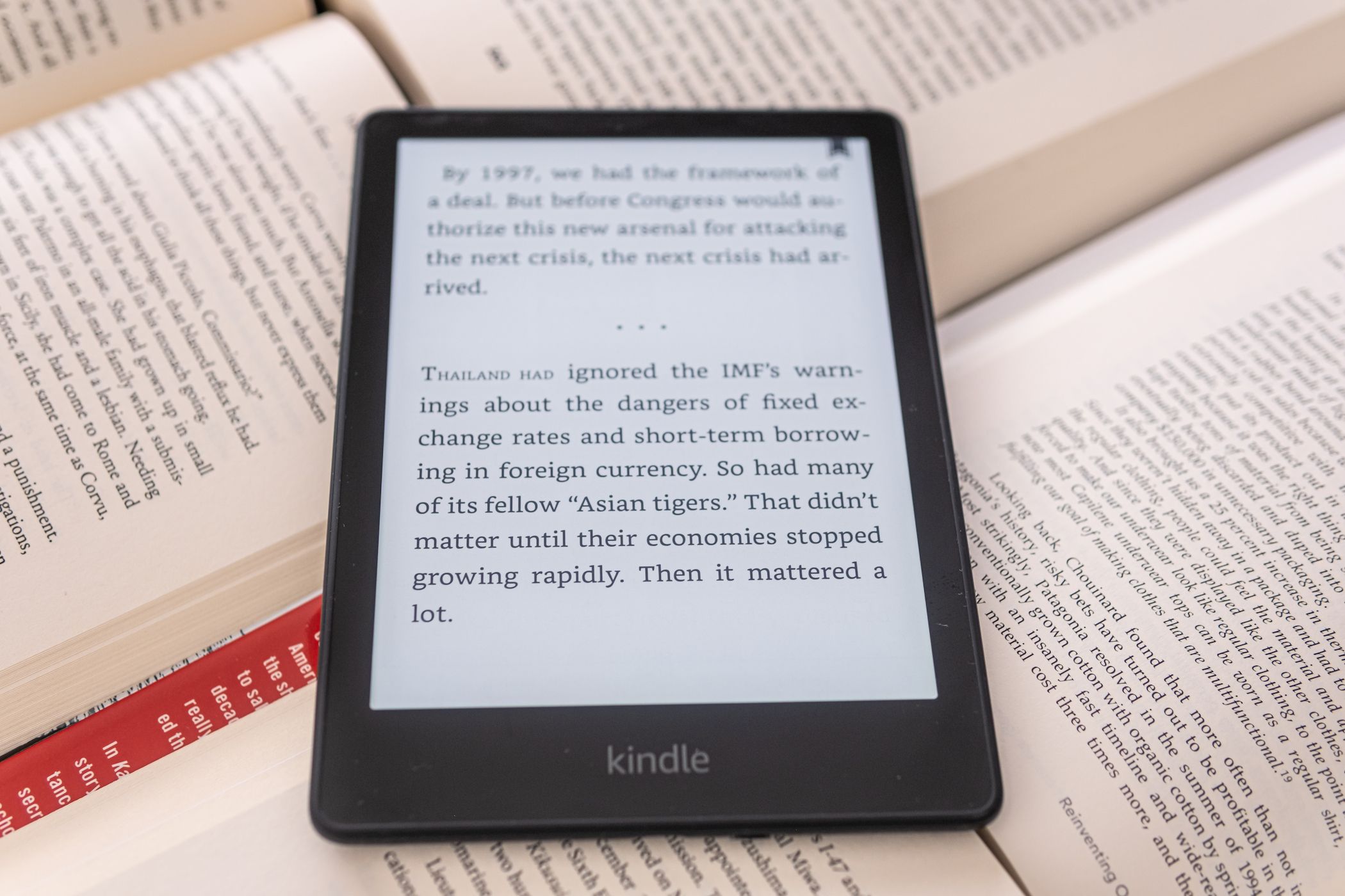 kindle ereader on top of real book