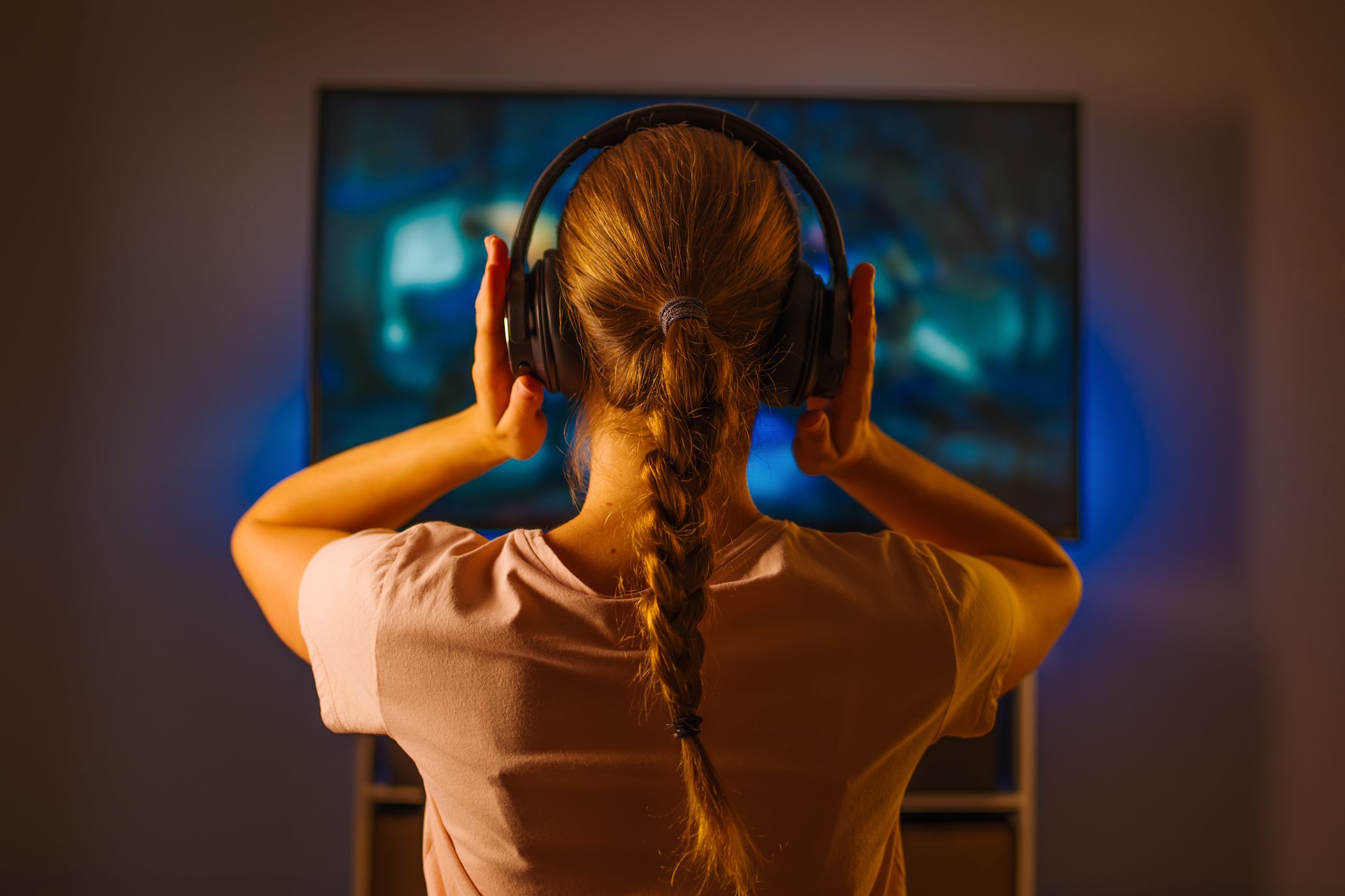 young woman watching tv wearing headphones