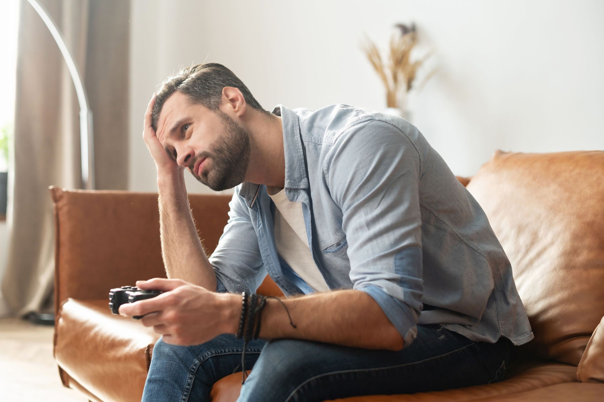 a gamer on a couch looking disappointed