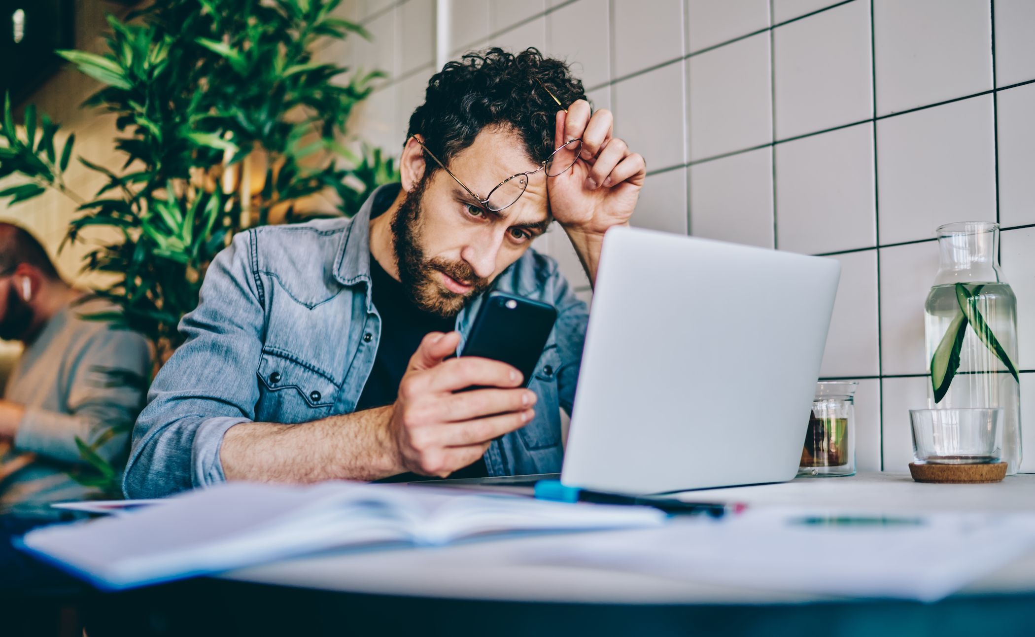 A man getting distracted at work by his phone