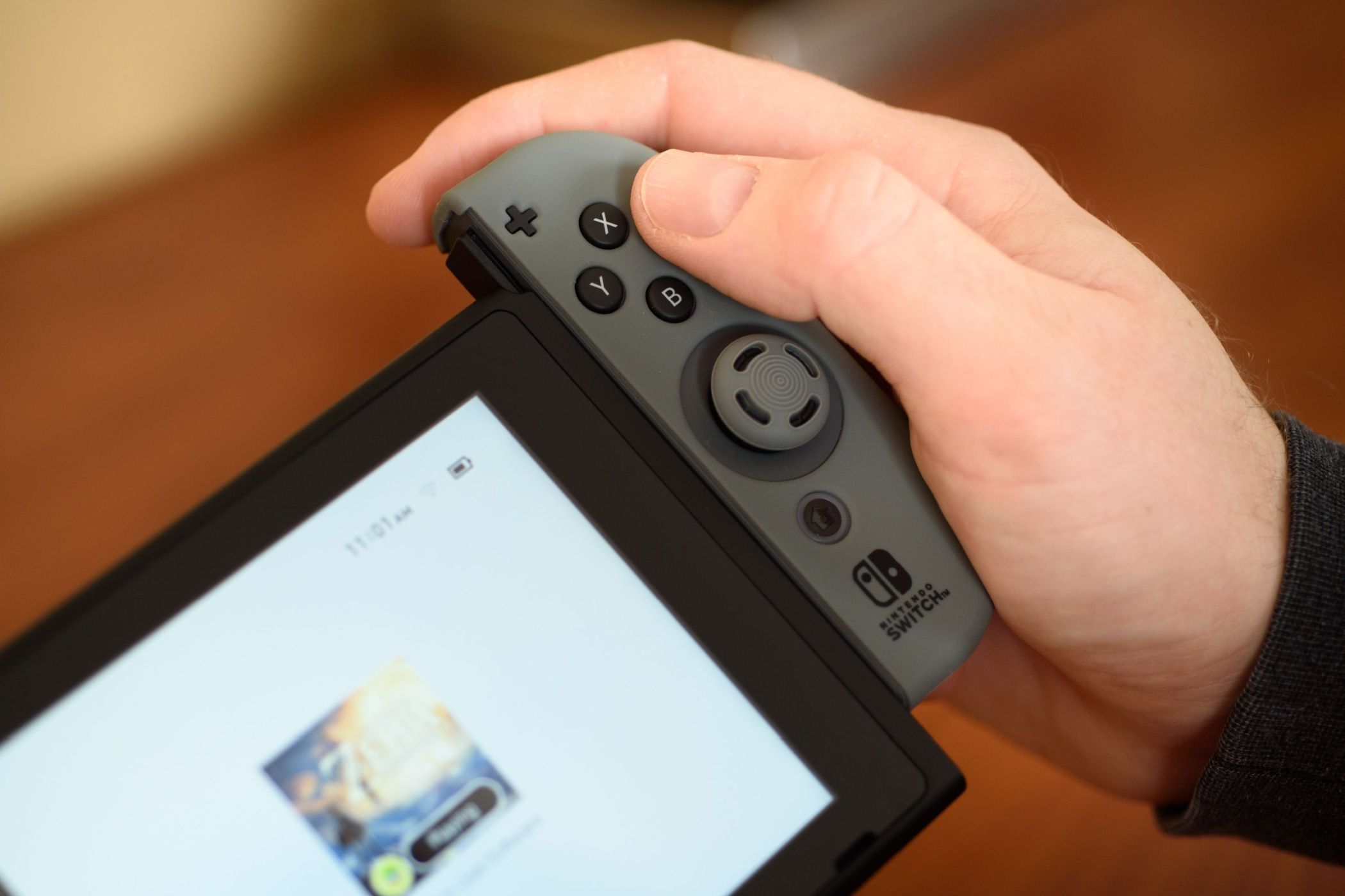 شخصی که یک joycon را به سوئیچ نینتندو متصل می کند