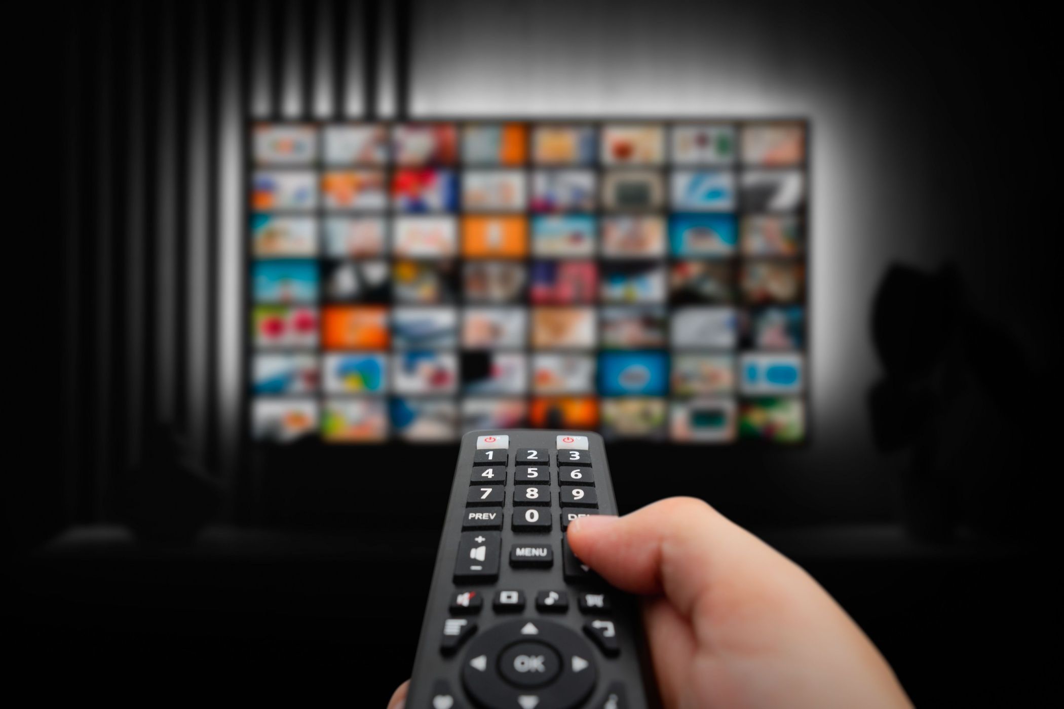 a tv remote pointing at a screen with a streaming service