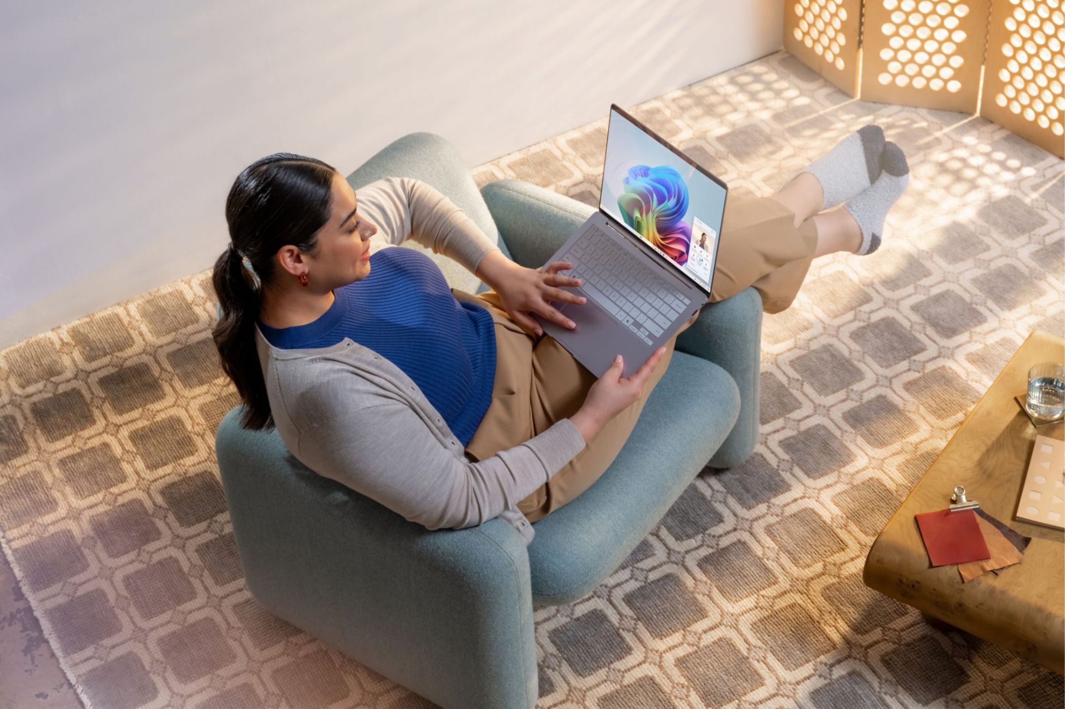 Woman in a chair with a laptop open to Microsoft Copilot 