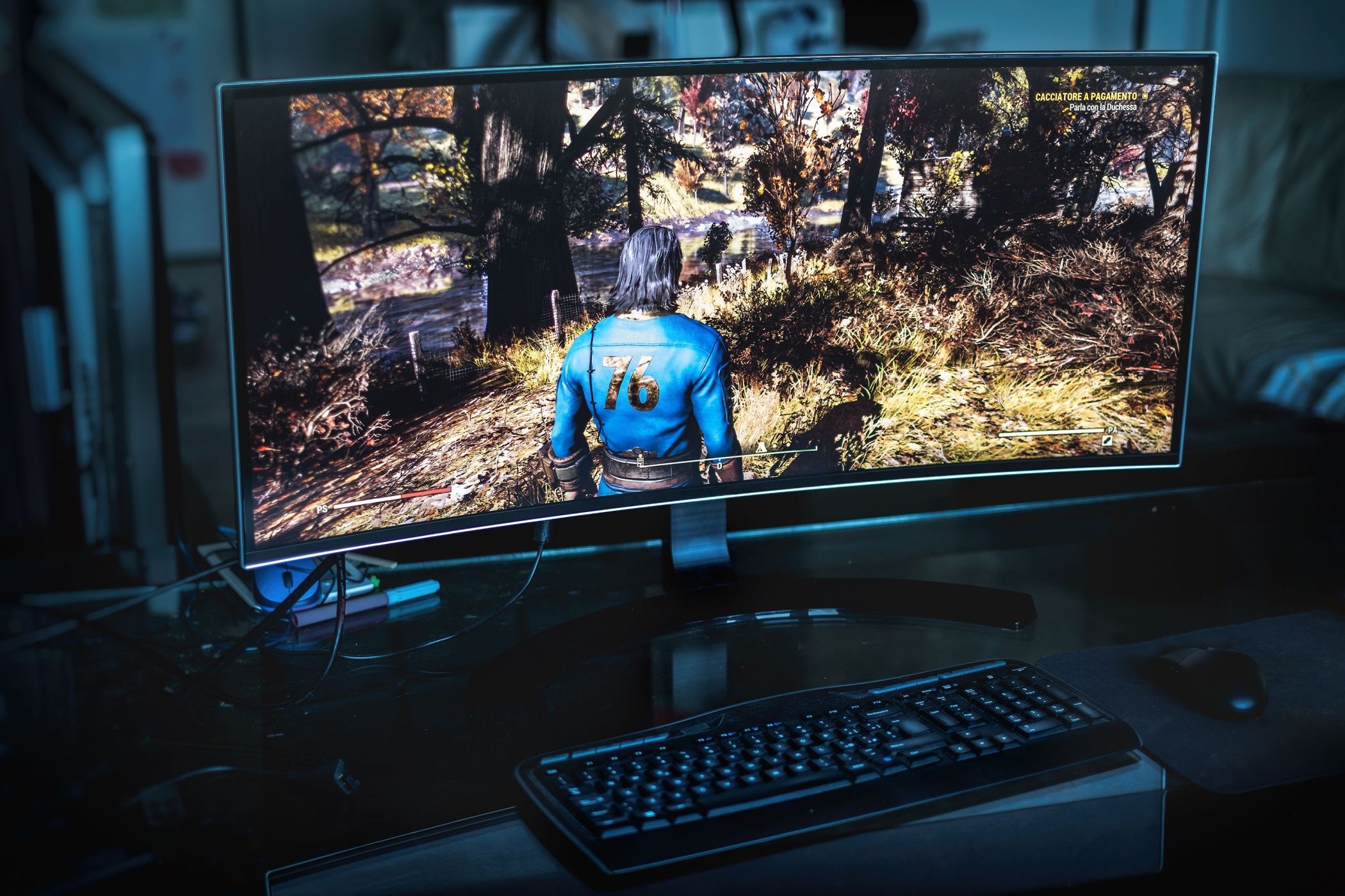 an ultrawide monitor with fallout 76 on the screen