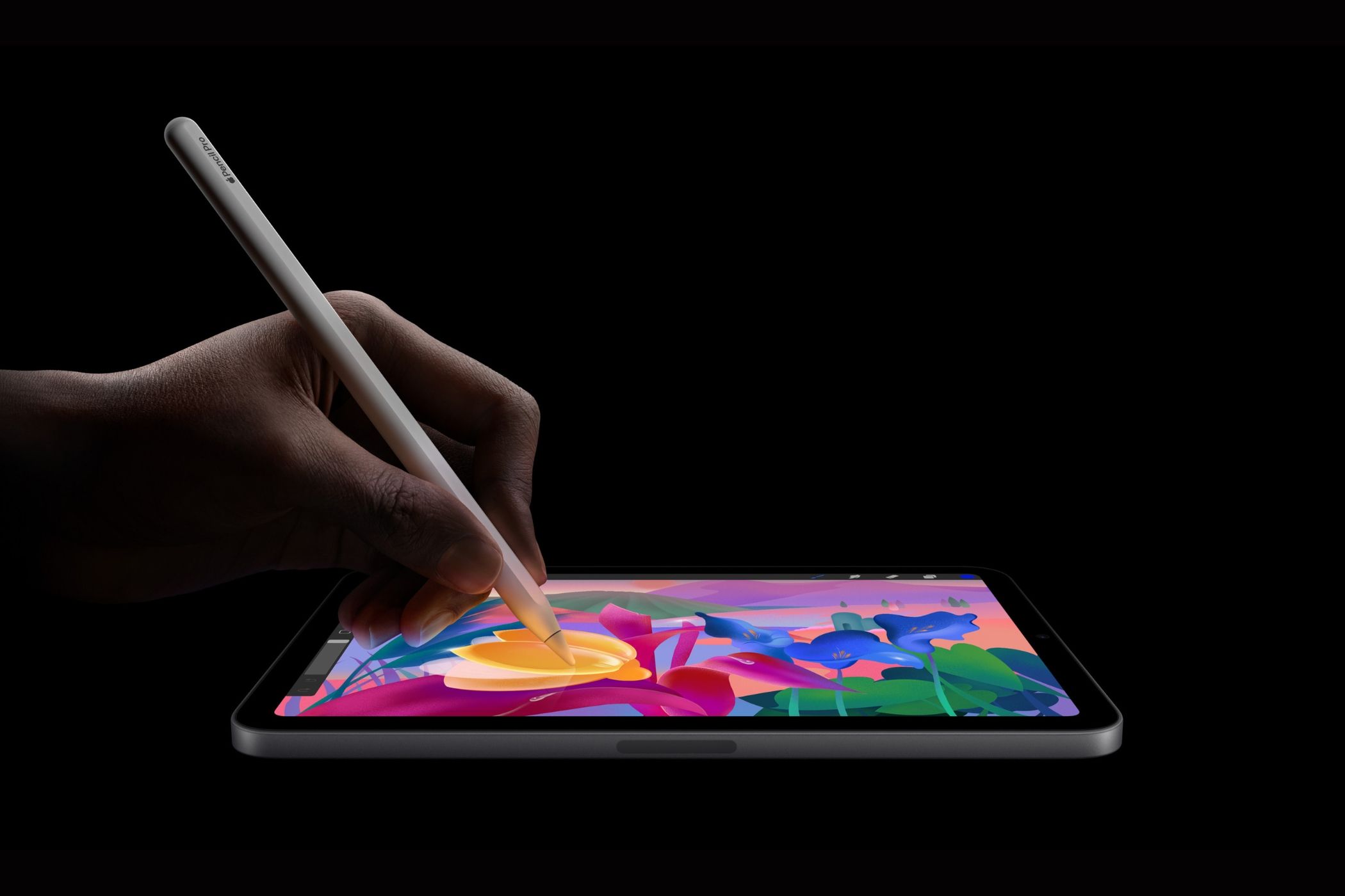 iPad mini placed flat down with a man using an Apple Pencil Pro to draw on the screen