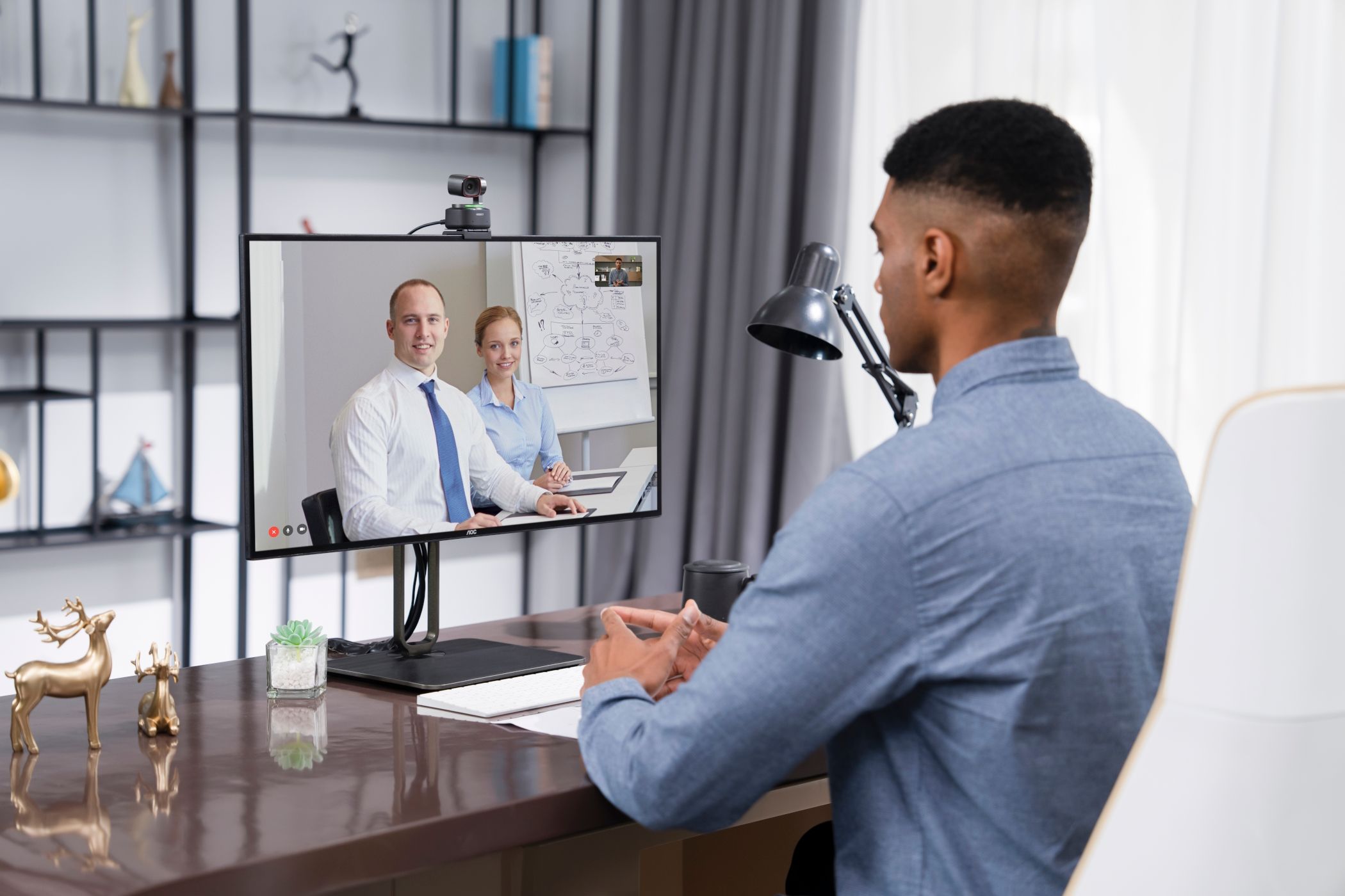 Man in video conference with OBSBOT Tiny 2 on monitor