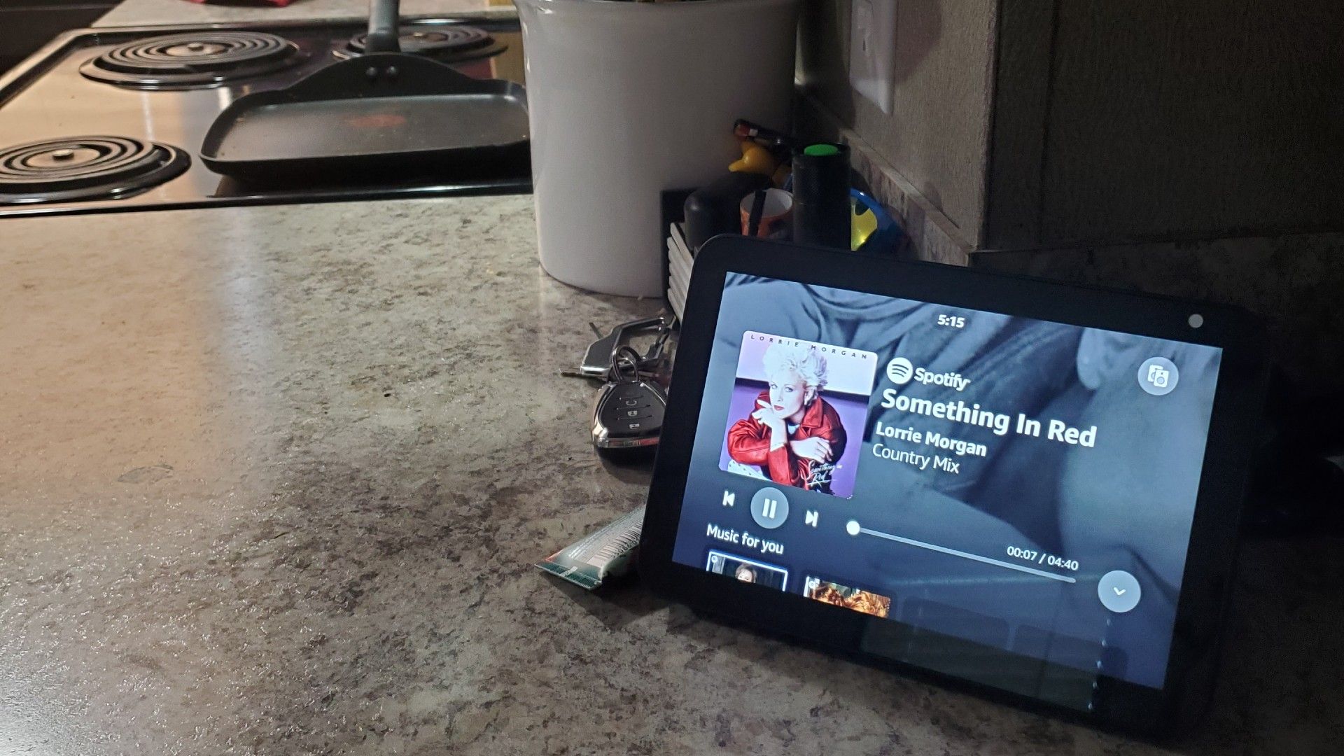 Echo show in kitchen displaying country song. 