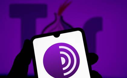 Person holding a phone showing the Tor browser logo