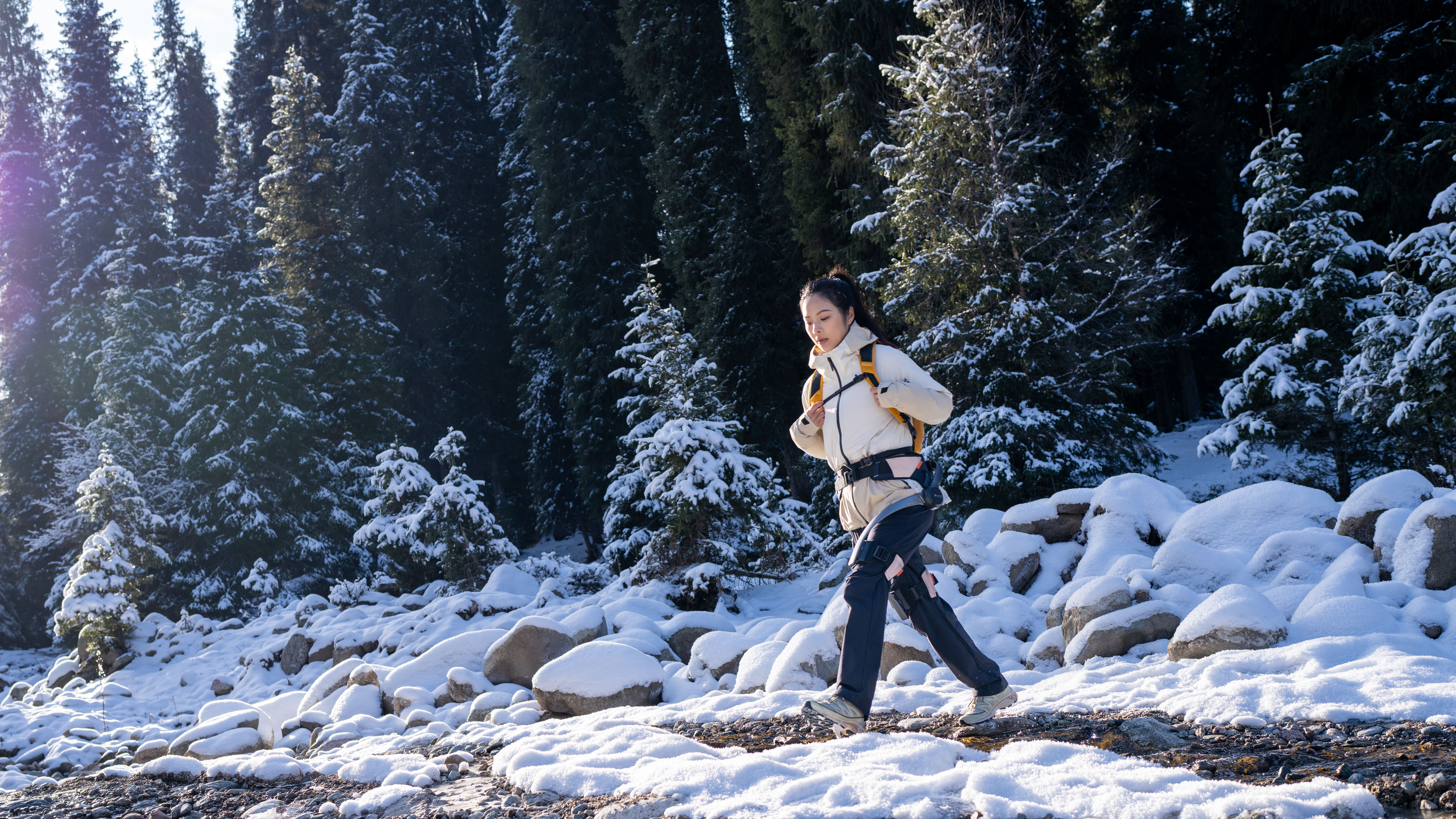 A woman treks through snowy terrain while wearing a Hypershell X.