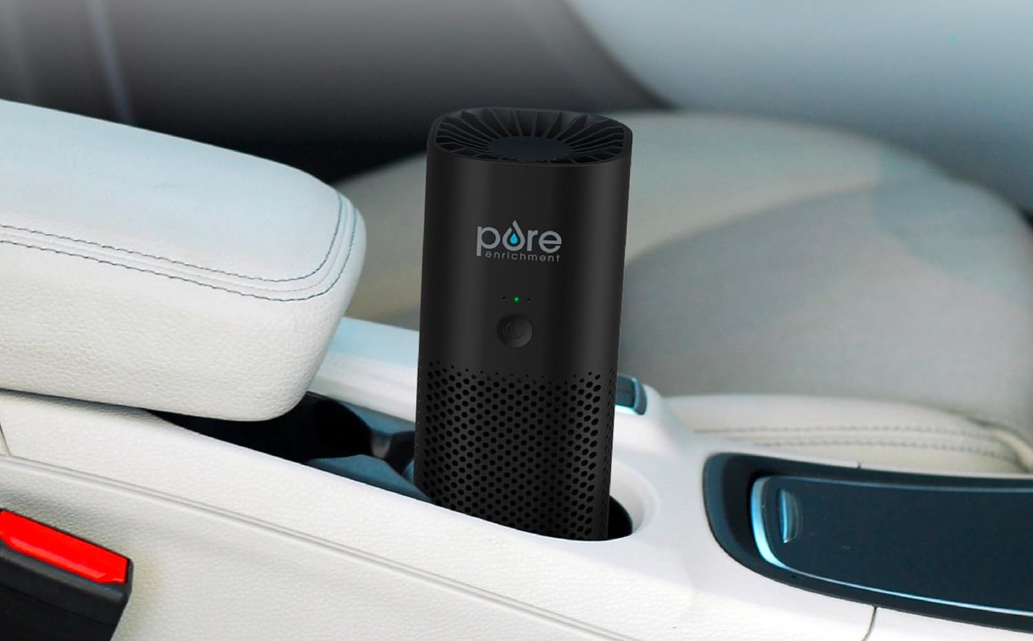 A portable air purifier in the cup holder of a car.