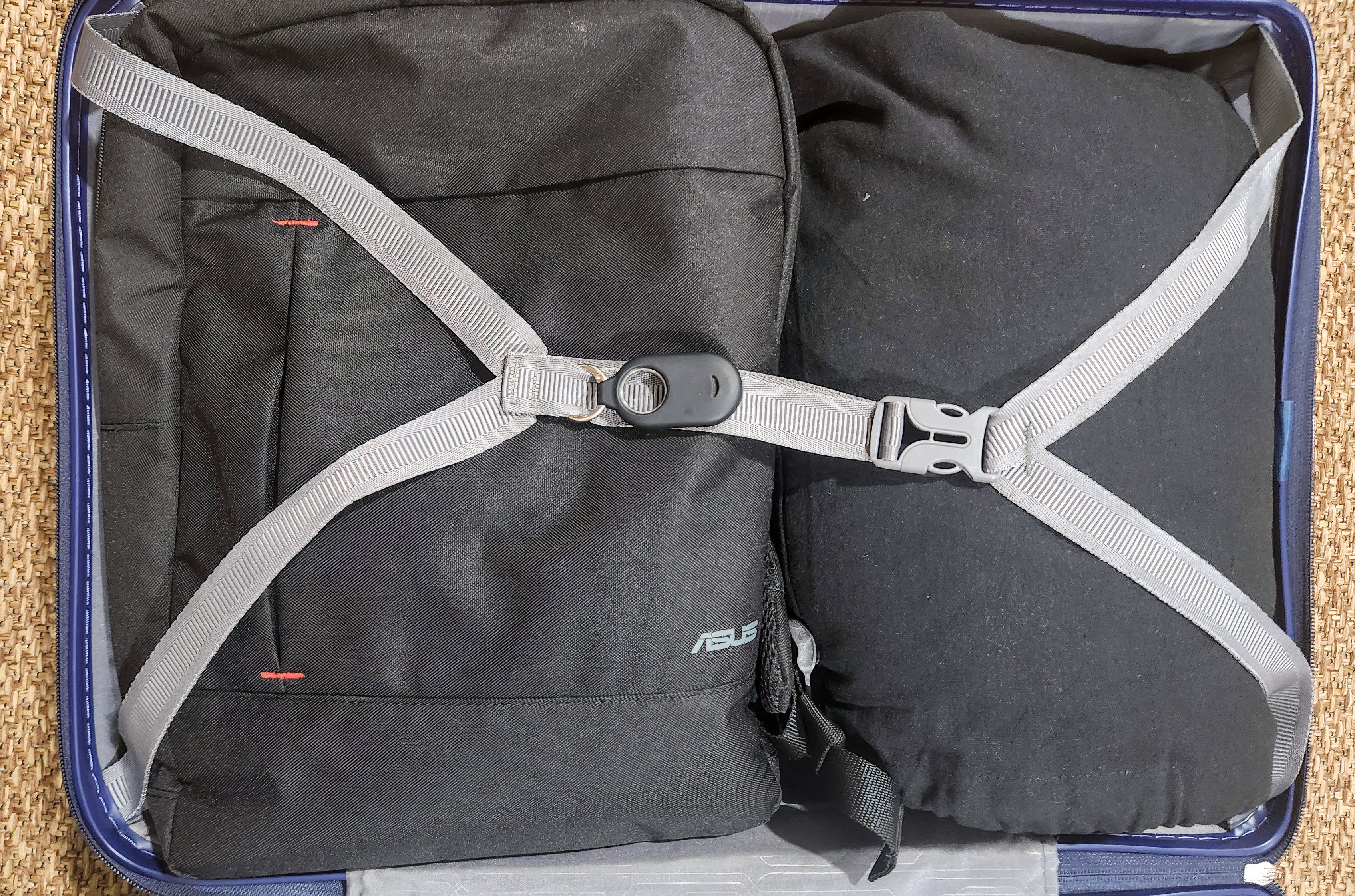 A tracker attached to a suitcase strap.
