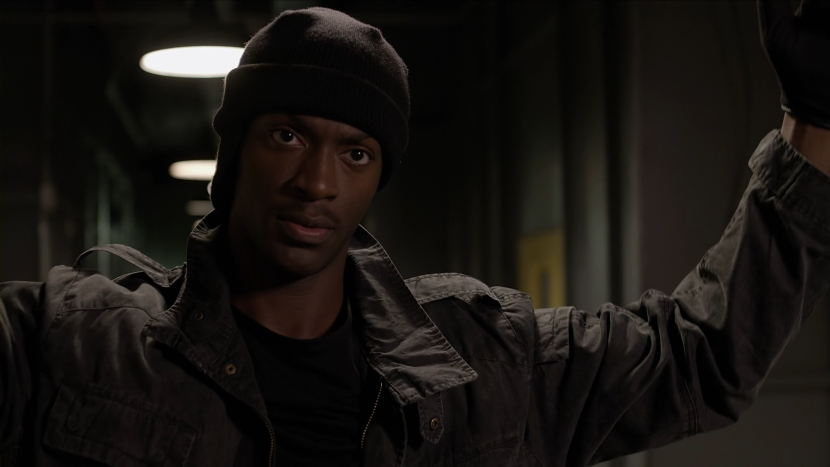 Aldis Hodge staring with his arms extended outward