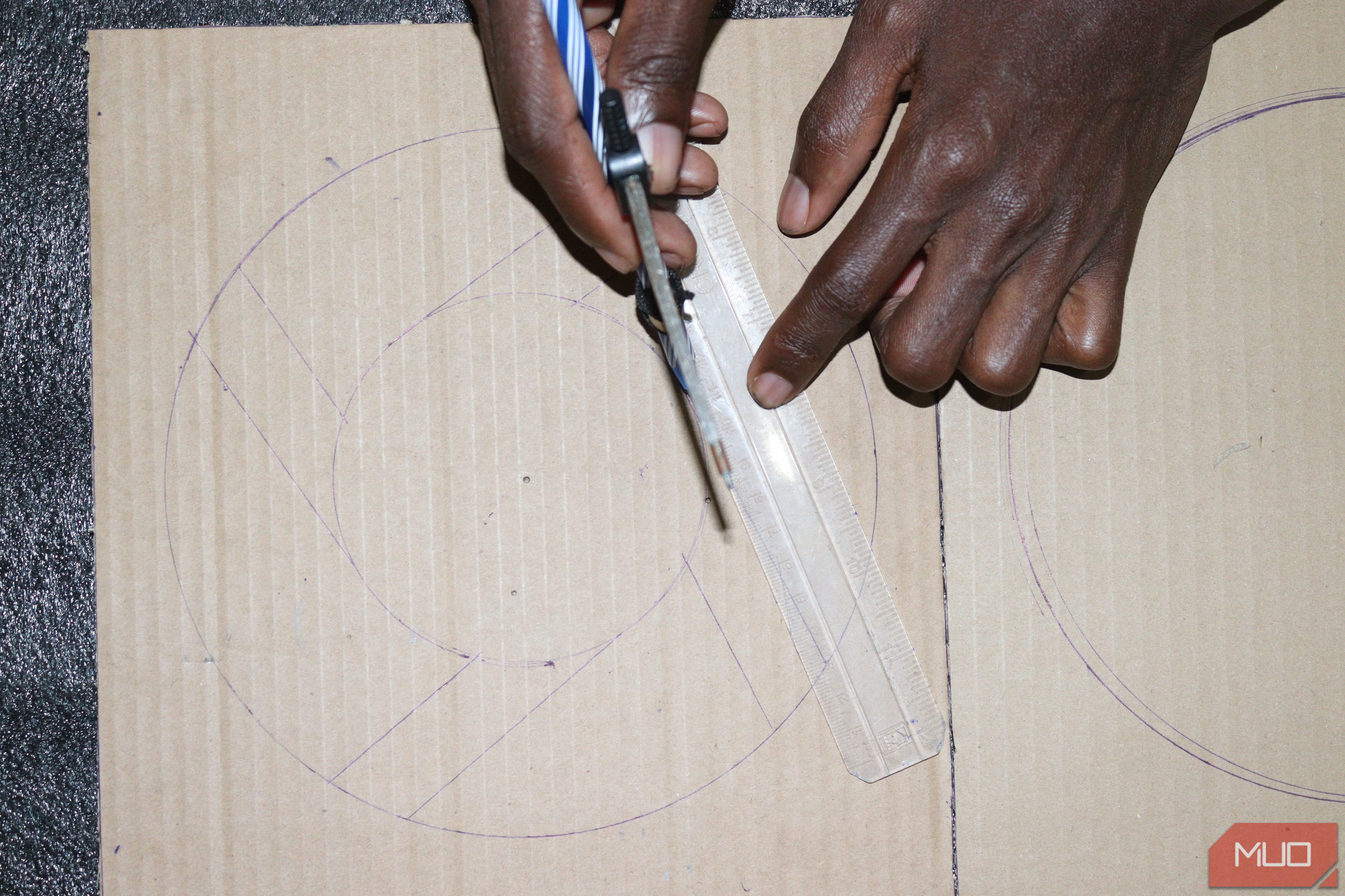 Using a compass, pen, and a ruler to draw the structure of a fan