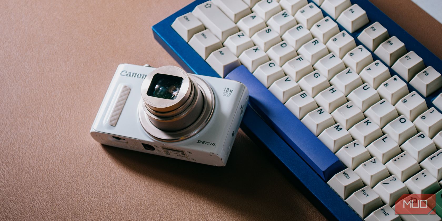 Máy ảnh Canon với ống kính mở rộng bên cạnh bàn phím