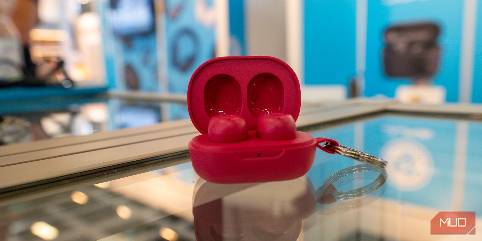 Closeup of red JBuds mini earpods on glass table 