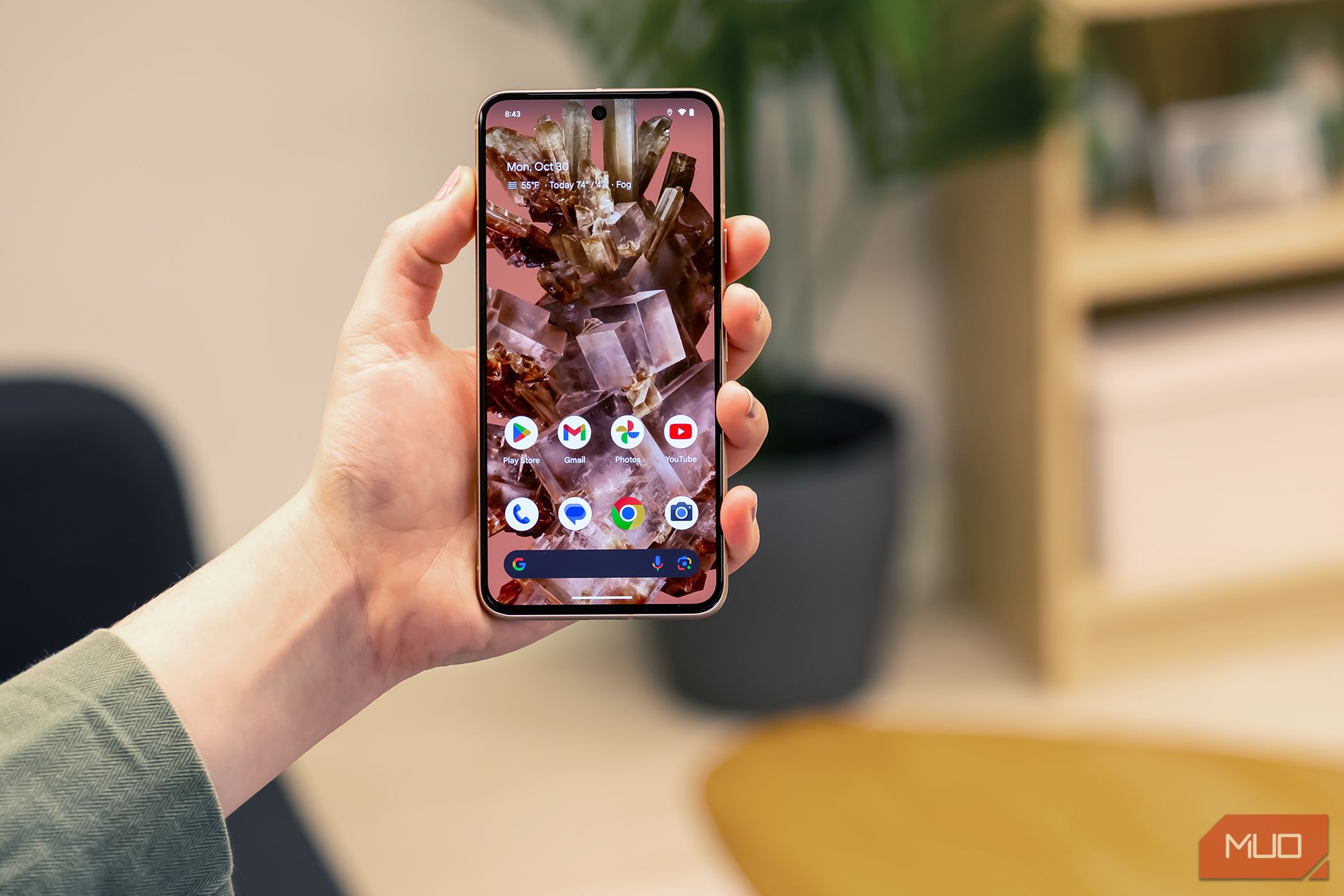 Person holding a Google Pixel 8 on the home screen