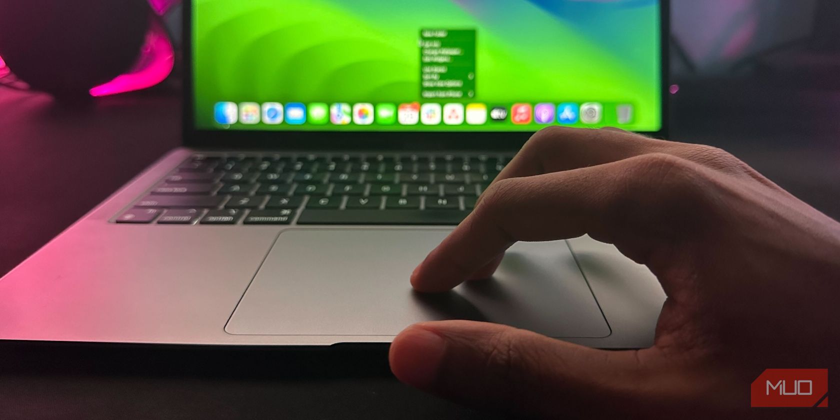 A MacBook user right-clicking on the trackpad