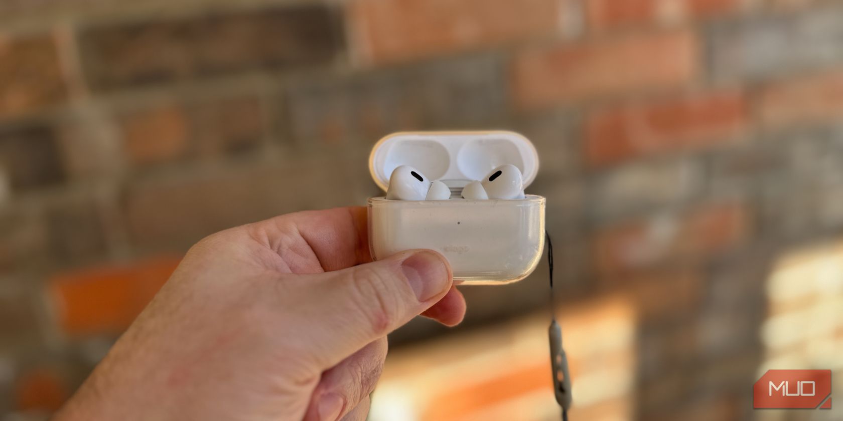 a person holding AirPods Pro enclosed in a case