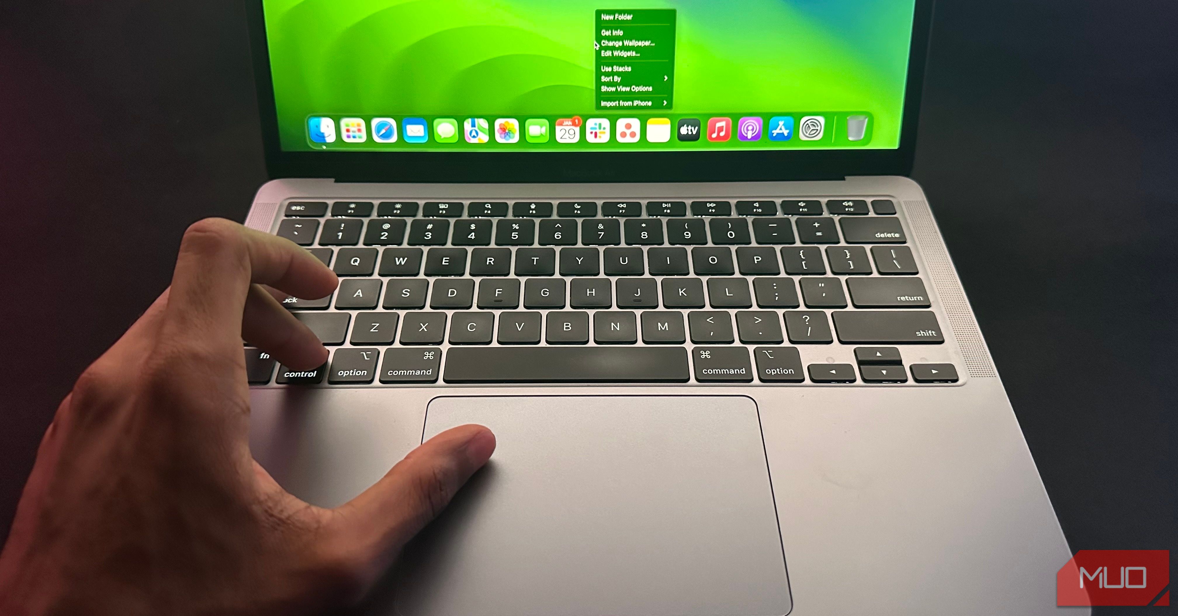 User right-clicking on a MacBook by pressing the Control key