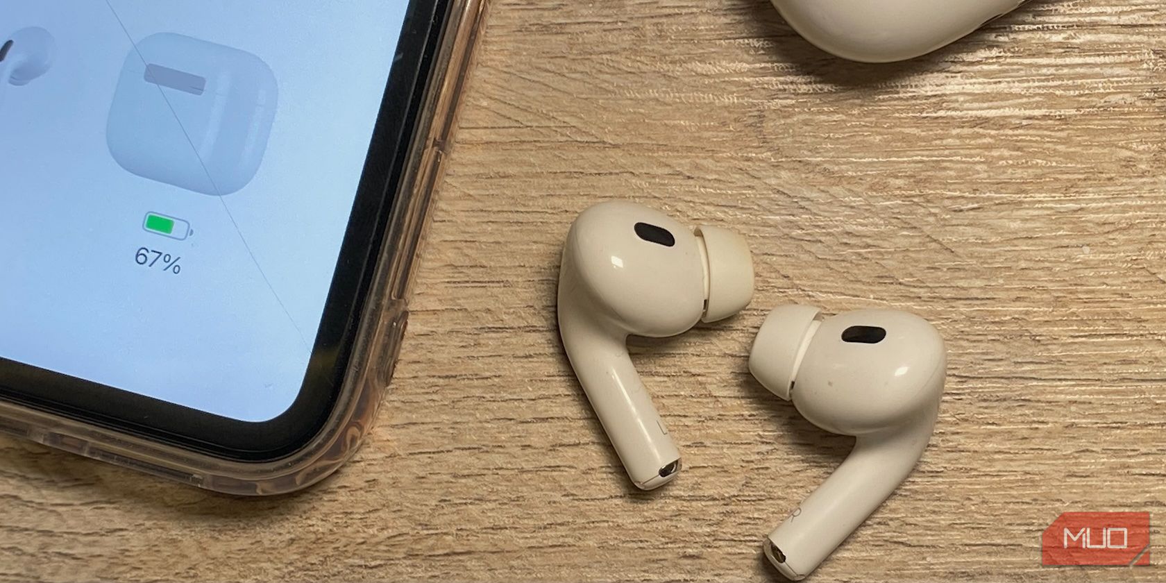 airpods on a wooden table besides an iPhone