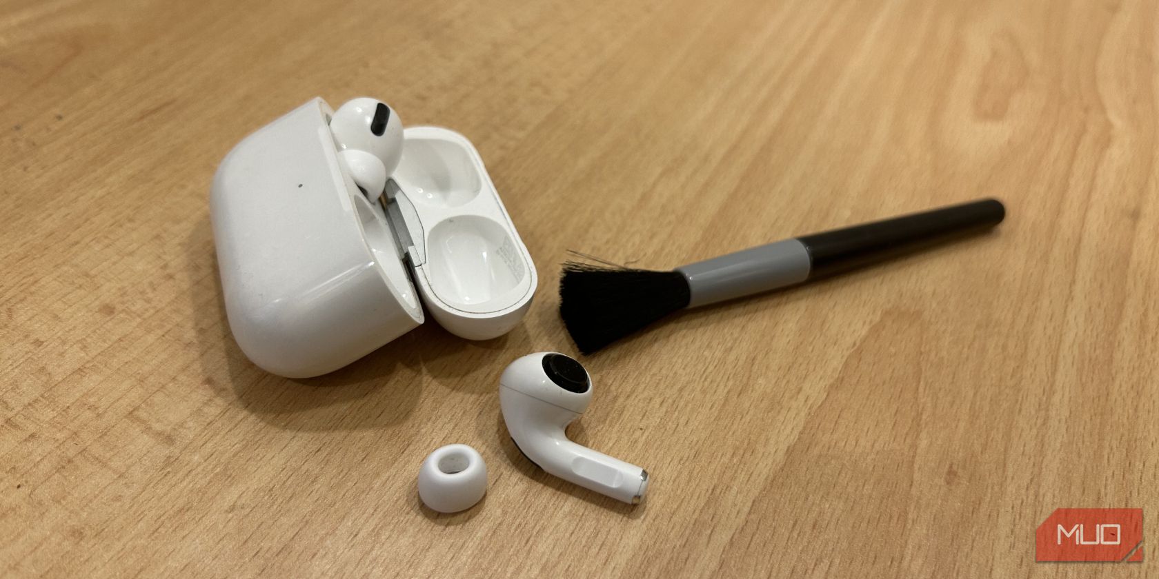 AirPods Pro روی میز با برس تمیزکننده.