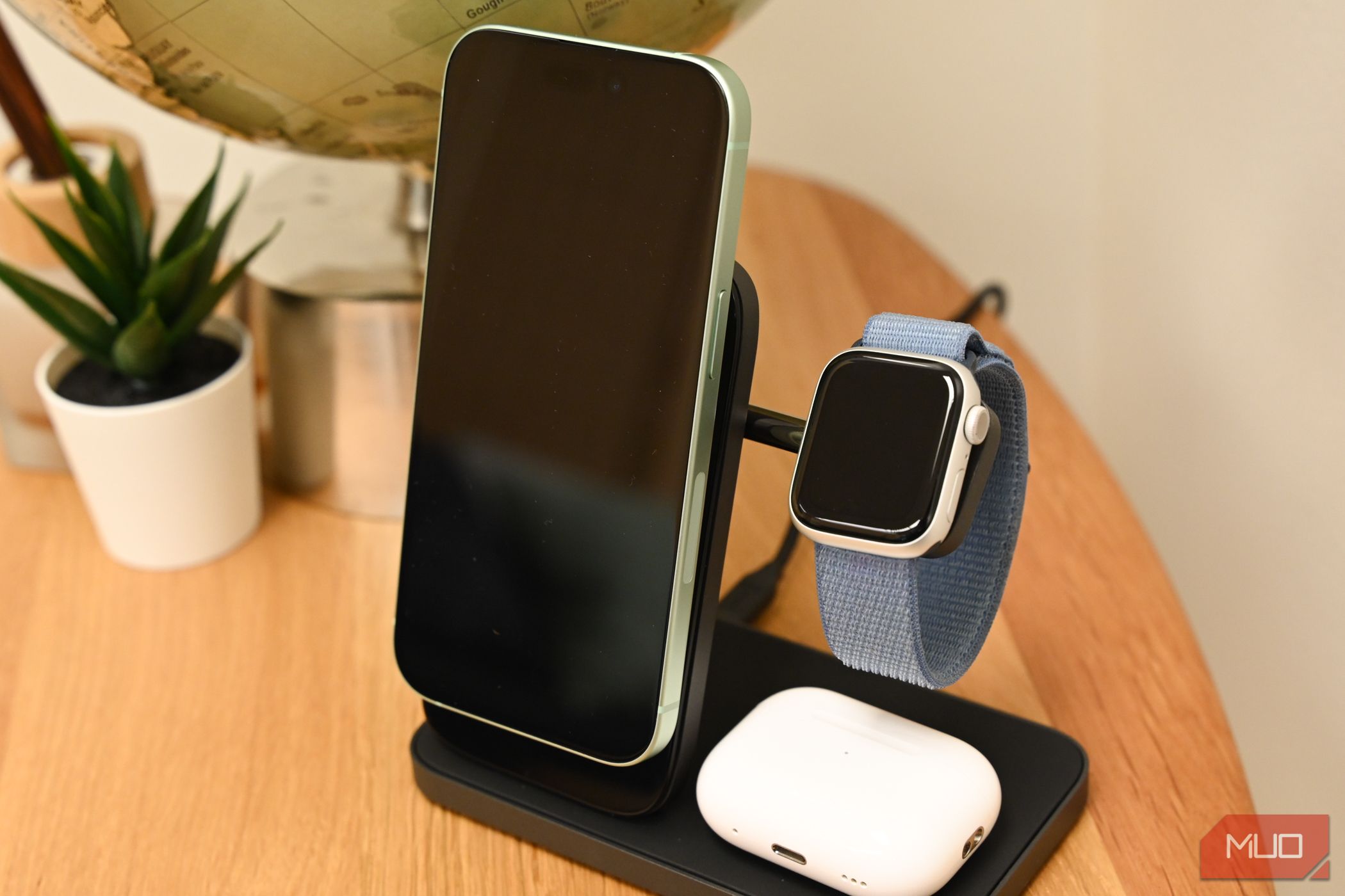 An iPhone, Apple Watch, and AirPods charging on the Nomad Stand One Max