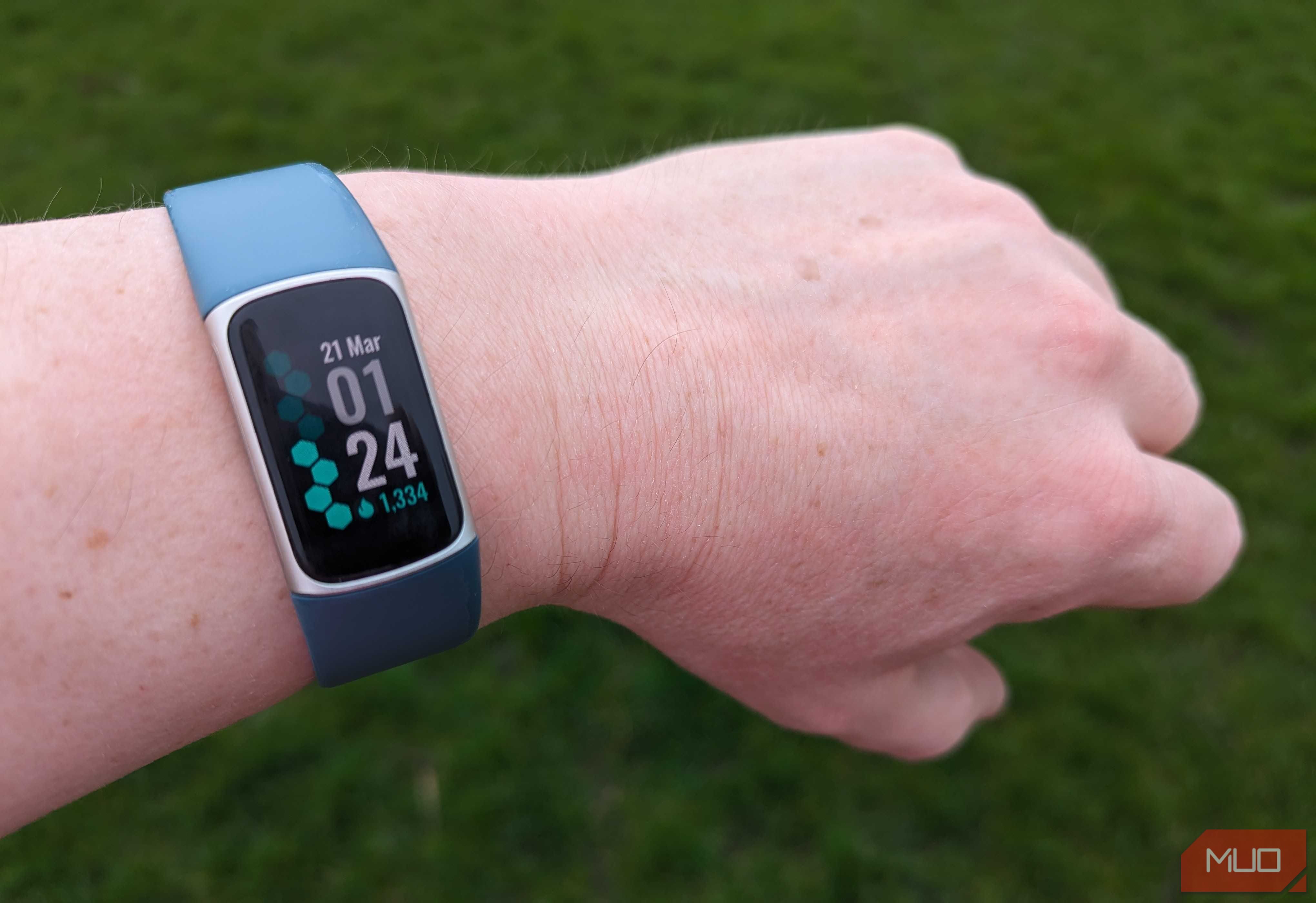 A Fitbit Charge 5 on a runner's wrist