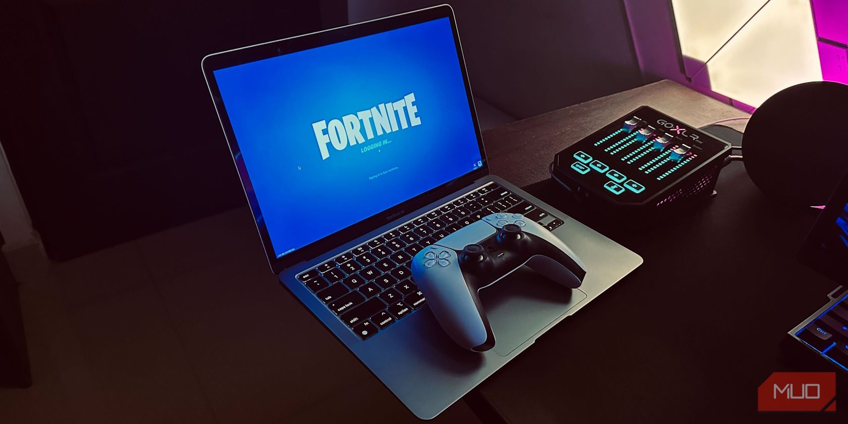 Fortnite running on a MacBook Air with a PS5 controller on top of it